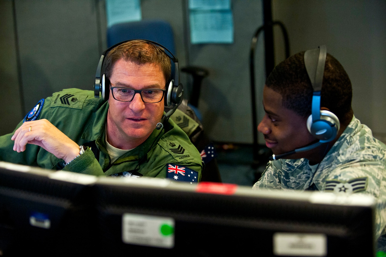 Royal Australian Air Force Flight Sgt. Sean Bedford (left), Australian Space Operations Centre space duty technician, New Norcia, Australia, and U.S. Air Force Senior Airman Frederick Riggans-Huguley, 603rd Air and Space Operations Center space duty technician, Ramstein Air Base, Germany, analyze air missile defense systems inside the Combined Air and Space Operations Center-Nellis during Red Flag 14-1 Feb. 5, 2014, at Nellis Air Force Base, Nev. Space duty technicians direct air missile ballistic warnings and provide communication to combat search and rescue teams. (U.S. Air Force photo/Senior Airman Brett Clashman)