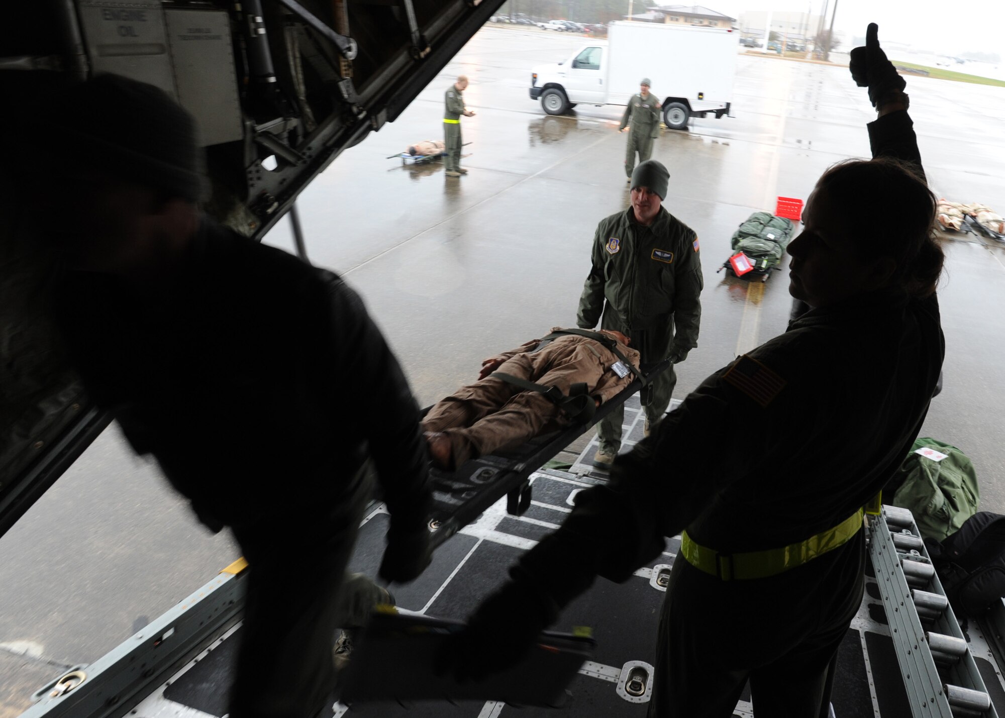 2nd Lt. Candi Hicks, a flight nurse with the 94th Air Wing, Dobbins AFB, Ga., signals “thumbs up” to aeromedical evacuation technicians while directing them to load a litter-borne mannequin onto a C-130H aircraft during Hicks’ final flight evaluation at Pope Field, N.C., on Mar. 7, 2014.  The final flight evaluation is the culmination of nearly seven months of training Airmen undergo while earning a flight nurse certification, which allows the officer to command an in-flight medical crew.  (U.S. Air Force photo by Tech. Sgt. Peter R. Miller)