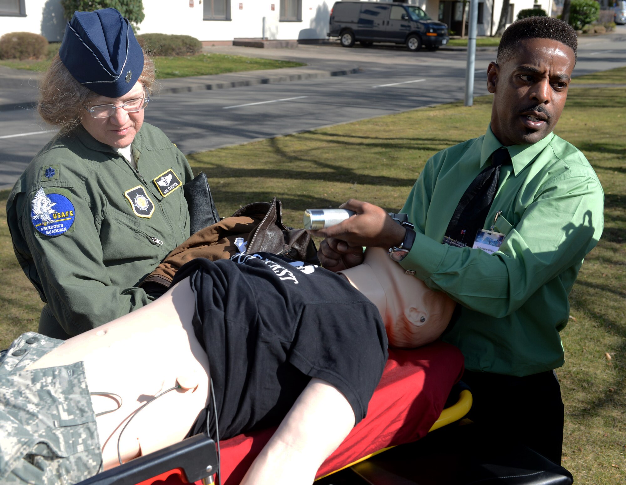 RAMSTEIN AIR BASE, Germany -- Christopher Williams, 86th Medical Group simulator operator, demonstrates how human simulators can be used for medical training outside the Hercules Theater here March 10 as Lt. Col. Gail Fancher, Theater Patient Movement Requirement Center Europe theater validation flight surgeon looks on. The demonstration was part of the 29th Annual Aerospace Medicine Summit and NATO Science and Technology Organization Technical Course. The summit featured more than 170 attendees from 16 nations.  (U.S. Air Force Photo by Tech. Sgt. James M. Hodgman)