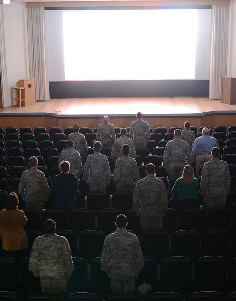 Patrons stand for the national anthem before the showing of "Ghost Army" in the Skyline Theater at Spangdahlem Air Base, Germany, March 11, 2014. The documentary chronicles the history of a secret World War II U.S. Army unit whose mission was to mislead and deceive the enemy with various tactics including recorded battle sounds, inflatable tanks and false radio broadcasts. (U.S. Air Force photo by Staff Sgt. Chad Warren/released)