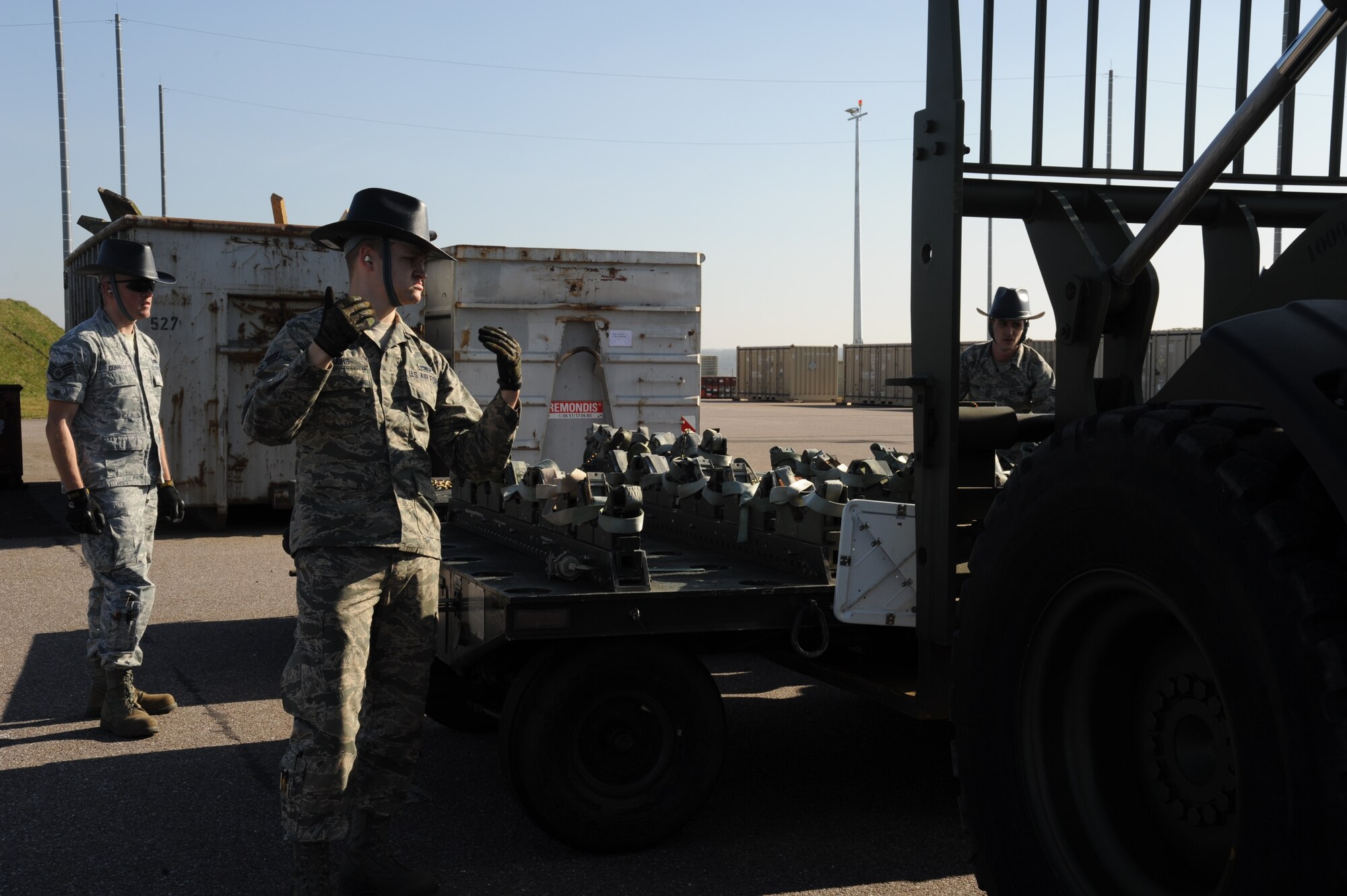 U.S. Air Force Senior Airman Randy Davis, 52nd Equipment Maintenance Squadron mission support equipment maintenance crew chief from Shelby, N.C., directs a forklift operator March 10, 2014, at Spangdahlem Air Base, Germany. Airmen use the trailers to transport munitions to the flight line for aircraft. (U.S. Air Force photo by Airman 1st Class Dylan Nuckolls/Released)