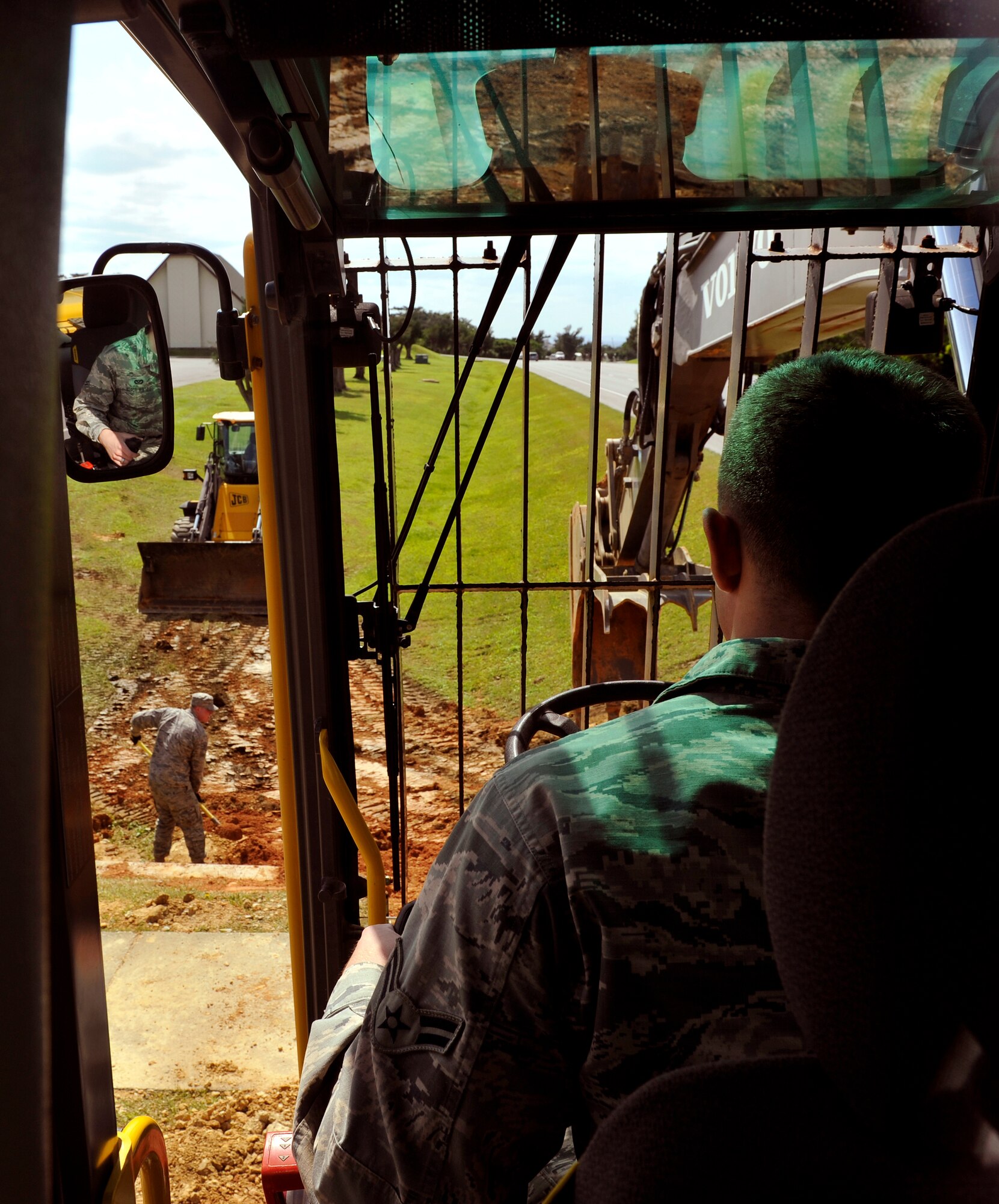 U.S. Air Force Airman 1st Class Sean Hayden, 18th Civil Engineer Squadron pavement equipment technician, operates an excavator near Chapel One on Kadena Air Base, Japan, March 11, 2014. Members of 18th CES replaced a broken water pipe where it flooded near Chapel One and used an excavator to fill the hole. (U.S. Air Force photo by Naoto Anazawa) 