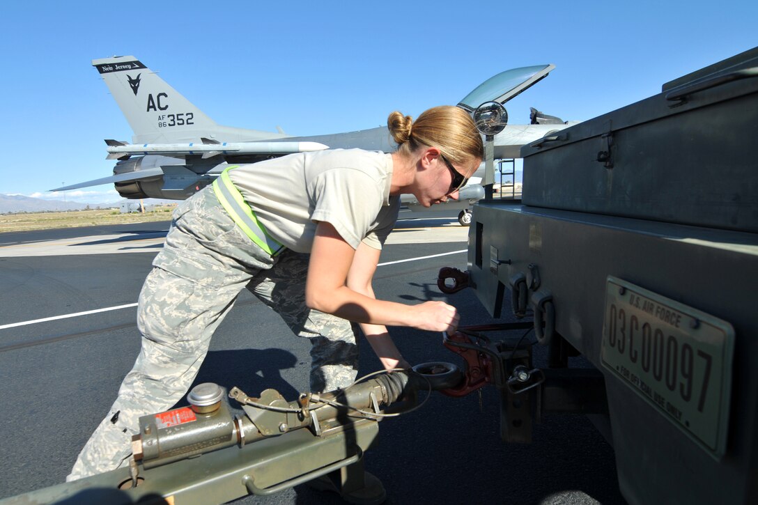 Air Force Staff Sgt. Jennifer Lauer attaches a munitions trailer to a tow vehicle during Operation Snowbird on Davis-Monthan Air Force Base, Ariz., March 3, 2014. Lauer, a munitions systems specialist, is assigned to New Jersey Air National Guard's 177th Fighter Wing.