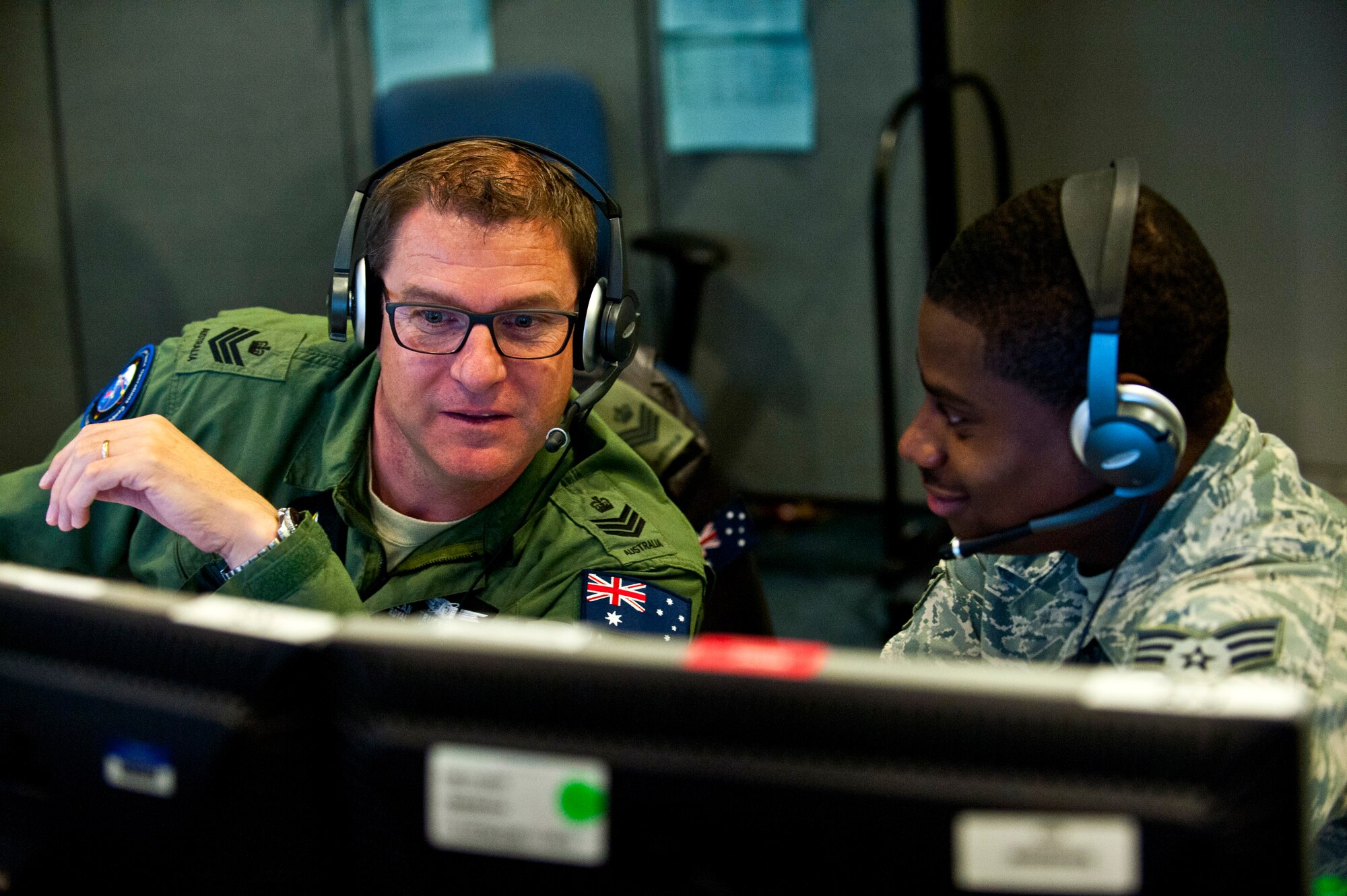 Royal Australian Air Force Flight Sgt. Sean Bedford (left) and U.S. Air Force Senior Airman Frederick analyze air missile defense systems inside the Combined Air and Space Operations Center-Nellis during Red Flag 14-1 Feb. 5, 2014, at Nellis Air Force Base, Nev. Space duty technicians direct air missile ballistic warnings and provide communication to combat search and rescue teams.  Beford is an Australian Space Operations Centre space duty technician and Frederick is a 603rd Air and Space Operations Center space duty technician.  (U.S. Air Force photo/Senior Airman Brett Clashman) 