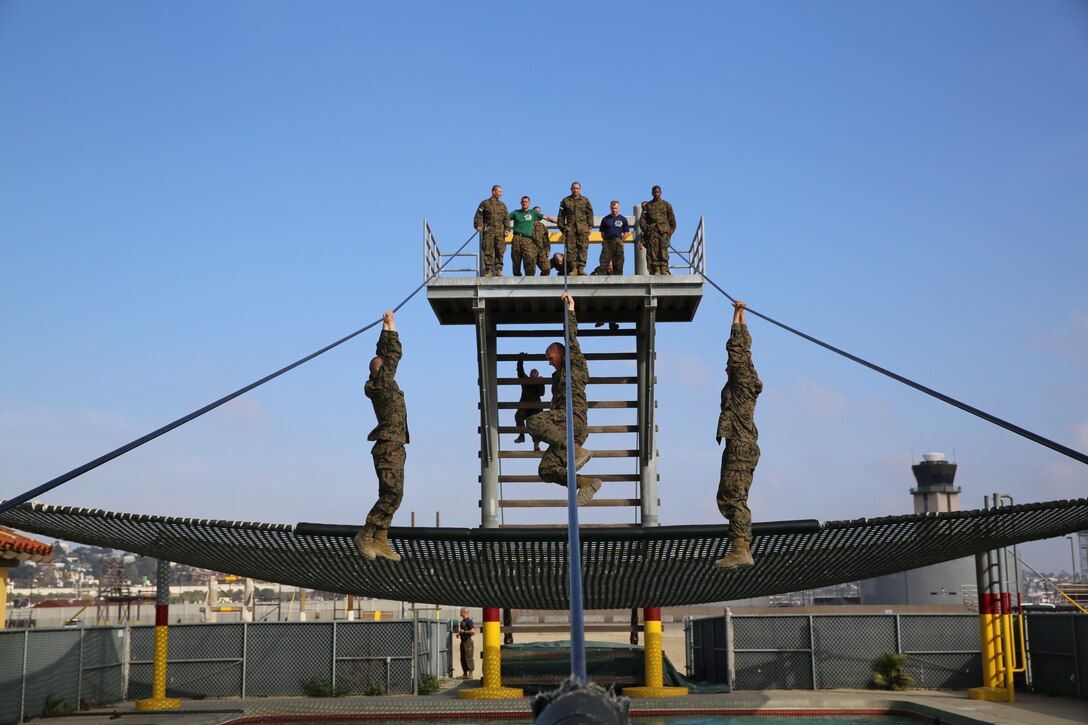 Recruits of Company M, 3rd Recruit Training Battalion, hang on as they attempt to switch grips during the Slide for Life obstacle during the Confidence Course aboard the depot, Feb. 25.  The Slide for Life was one of the most physically demanding obstacles in the course where recruits were tested on their physical endurance and mental strength.