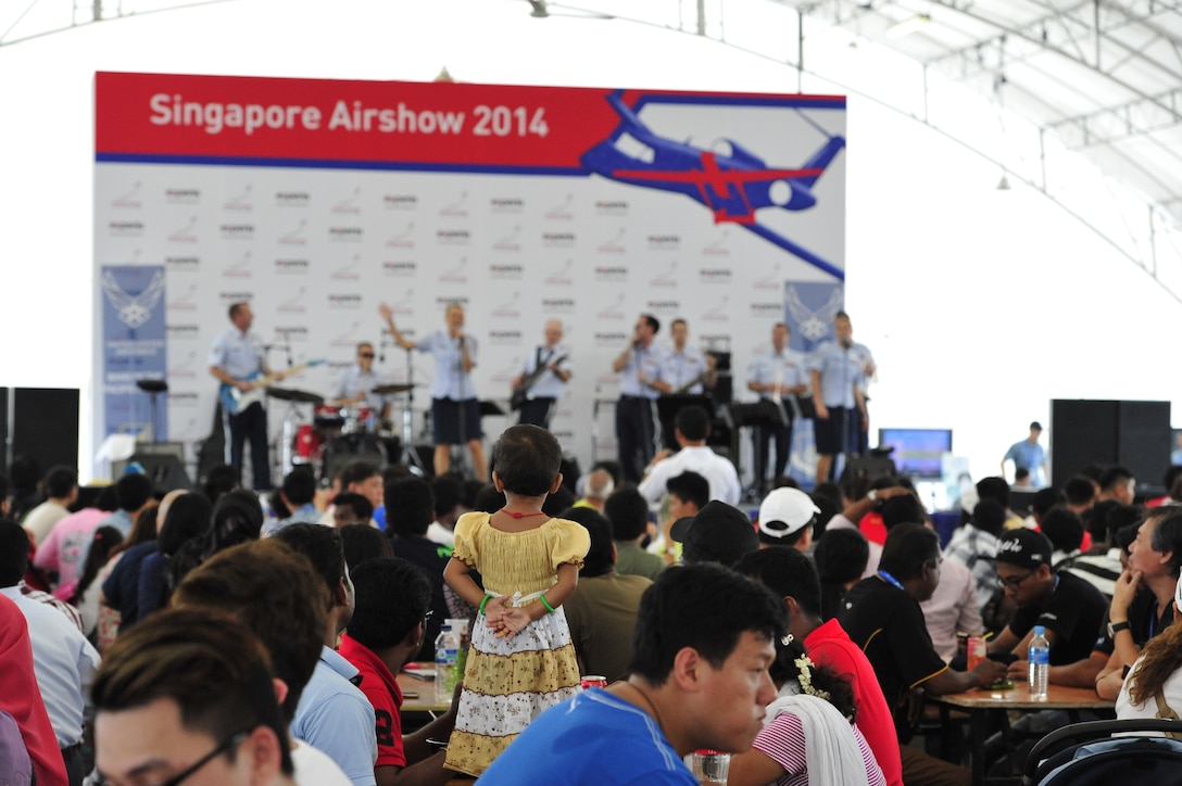 CHANGI, Singapore-- A little girl enjoys the sights and sounds of " Hana Hou!" at the Singapore Air Show,  Feb. 16, 2014. The group played 9 shows to over 100K audience members throughout their tour. The Band of the Pacific-Hawaii went to Singapore in support of the air show, the U.S. Embassy, and to improve international relations. (US Air Force Photo/ SrA Andy Detra/released)