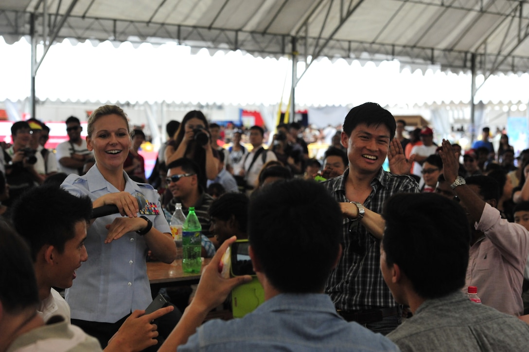 CHANGI, Singapore-- SSgt Courtney Clifford convinces a member of the audience to dance with her at the Singapore Air Show,  Feb. 16, 2014. The group played 9 shows to over 100K audience members throughout their tour. The Band of the Pacific-Hawaii went to Singapore in support of the air show, the U.S. Embassy, and to improve international relations. (US Air Force Photo/ SrA Andy Detra/released)