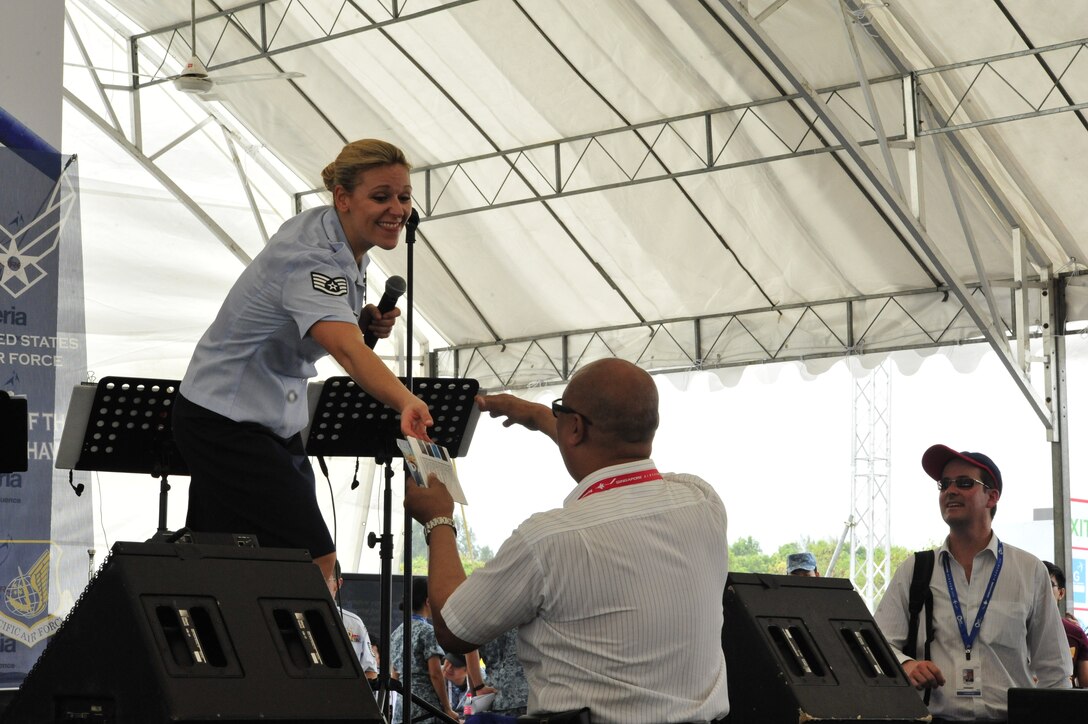 CHANGI, Singapore--SSgt Courtney Clifford awards a free CD,recorded by "Papana",USAF Band of the Pacific-Hawaii, to an audience member at the Singapore Air Show, Feb. 12, 2014. The group played 9 shows to over 100K audience members throughout their tour. The Band of the Pacific-Hawaii went to Singapore in support of the air show, the U.S. Embassy, and to improve international relations. (US Air Force Photo/ SrA Andy Detra/released)