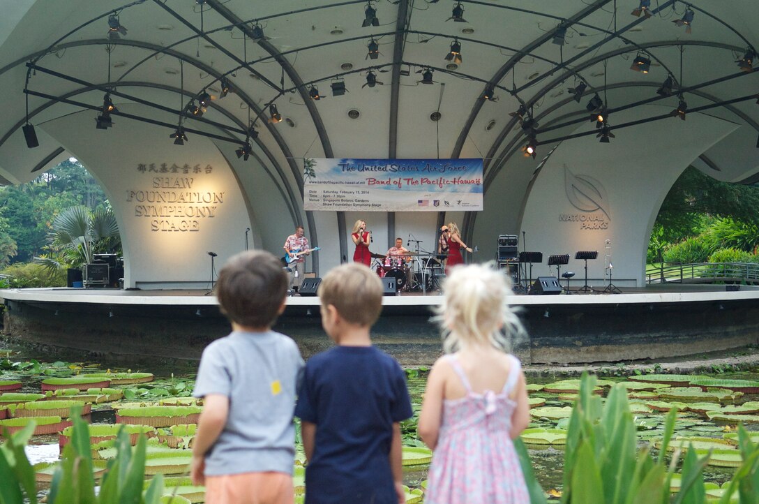 CHANGI, Singapore-- Three small children watch the band perform at the Singapore Botanic Garden, Feb. 15, 2014. The group played 9 shows to over 100K audience members throughout their tour. The Band of the Pacific-Hawaii went to Singapore in support of the air show, the U.S. Embassy, and to improve international relations. (US Air Force Photo/ SrA Andy Detra/released)