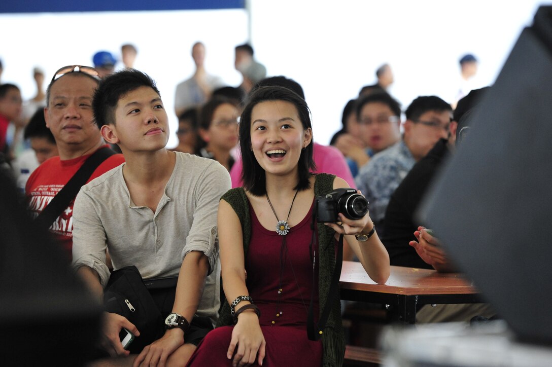 CHANGI, Singapore-- Audience members laugh and sing along during a performance by "Hana Hou!" ,Feb. 12, 2014.The group played 9 shows to over 100K audience members throughout their tour. The Band of the Pacific-Hawaii went to Singapore in support of the air show, the U.S. Embassy, and to improve international relations. (US Air Force Photo/ SrA Andy Detra/released)