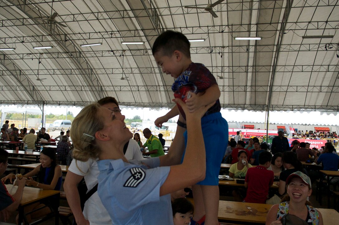 CHANGI, Singapore-- SSgt Courtney Clifford spends time with an amazing and friendly family at the Singapore Air Show, Feb. 16, 2014.The group played 9 shows to over 100K audience members throughout their tour. The Band of the Pacific-Hawaii went to Singapore in support of the air show, the U.S. Embassy, and to improve international relations. (US Air Force Photo/ SrA Andy Detra/released)
