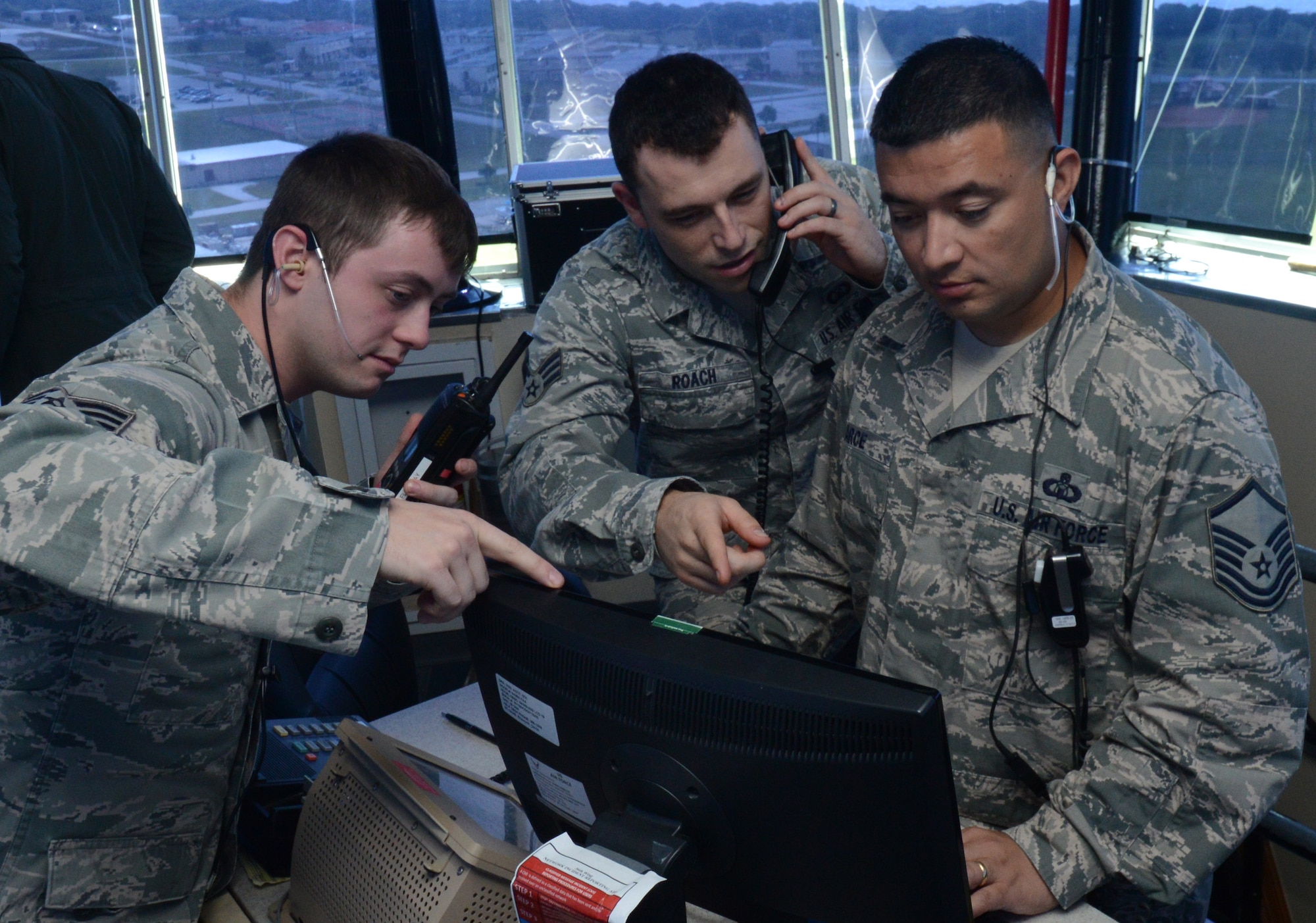 (From left) U. S. Air Force Senior Airmen Michael-Paul Kendall, Shaun Roach, and Master Sgt. Joseph Arce, 36th Operations Support Squadron air traffic controllers, look at the daily events log Feb. 24, 2014, on Andersen Air Force Base, Guam, during Exercise Cope North 2014. The exercise, which is a joint effort between the U.S. Air Force, the Japan Air Self-Defense Force and the Royal Australian Air Force, is designed for allies to work together on both humanitarian assistance and disaster relief (HA/DR) missions as well as large force employment mission with dissimilar aircraft. (U.S. Air Force photo by Airman 1st Class Emily A. Bradley/Released)