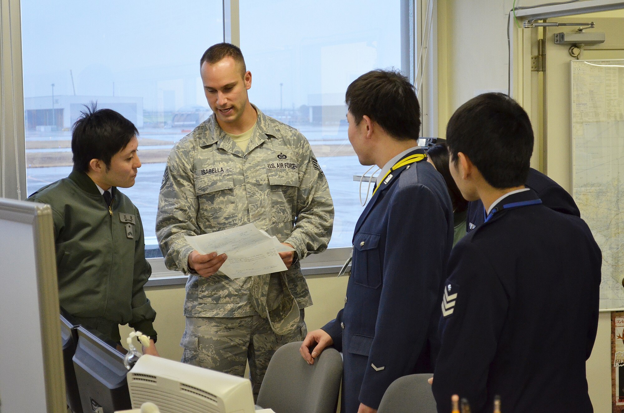 Staff Sgt. Anthony Isabella, 374th Operations Support Squadron Non-Commissioned Officer in charge of airfield management training, discusses aspects of the Airfield Management mission with his Japanese Air Self Defense Force counterparts as part of a bilateral exchange program at Komaki Air Base, Japan, March 5, 2014.  Eight NCO's from Yokota traveled to Komaki to see how their JASDF counterparts conducted their mission and to learn more about Japanese culture as part of the exchange. (U.S. Air Force photo by Tech. Sgt. Christopher Marasky/Released)