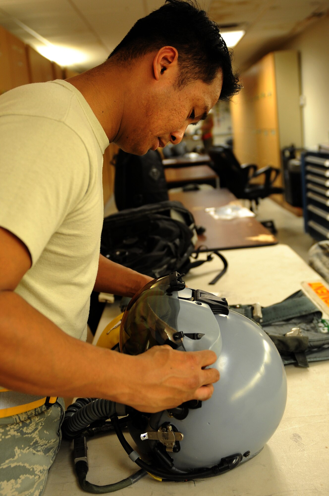 U.S. Air Force Tech. Sgt. Mark Natividad, 4th Operations Support Squadron NCO in charge of airfield flight equipment at Seymour Johnson Air Force Base, N.C., installs a visor on an F-15E Strike Eagle pilot’s helmet March 10, 2014, at Nellis AFB, Nev. During Red Flag 14-2, Natividad was charged with ensuring all helmets, oxygen systems and emergency flight equipment were serviceable when aircrew members stepped to their aircraft. (Air Force photo/Staff Sgt. Chuck Broadway)