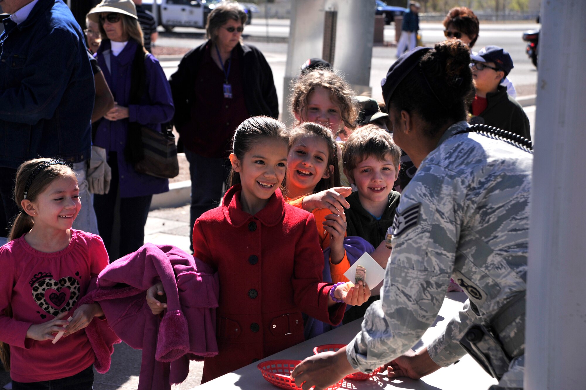 Children smile as they enter Creech Air Force Base, Nev., for Indian Springs Appreciation Day March 11, 2014. The annual event gives Airmen the opportunity to showcase the base mission, aircraft, and build relationships with the Indian Springs populace. (U.S. Air Force photo by Airman 1st Class C.C. /Released)