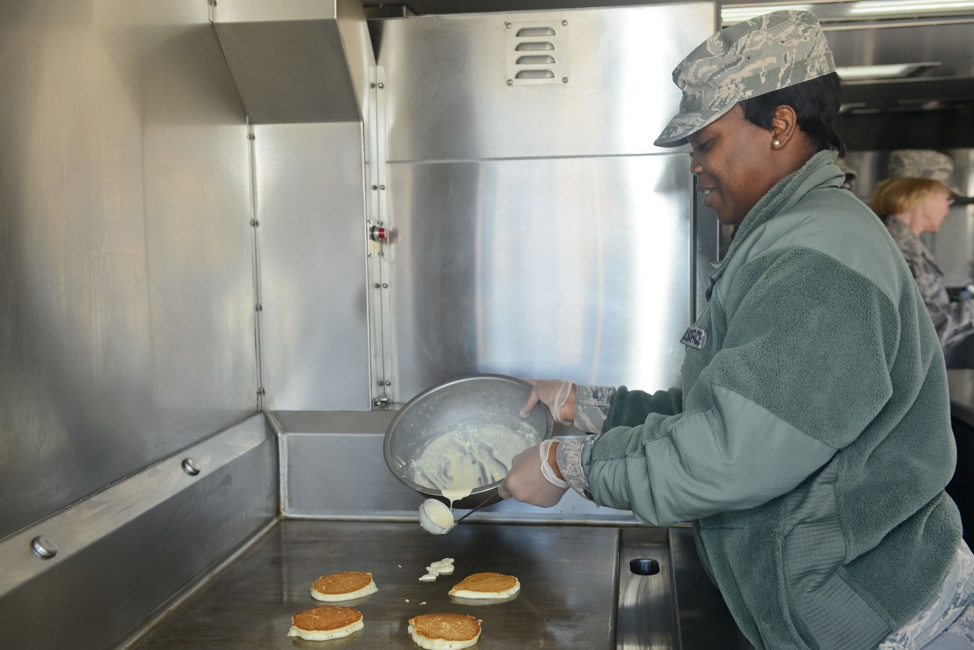 U.S. Air Force Senior Airman Deatrice Peake, 116th Force Support Squadron, Services Flight (FSS/FSV), Georgia Air National Guard, Robins Air Force Base, Ga., cooks pancakes on a grill in a Deployable Ready Mobile Kitchen Trailer (DRMKT) while training with the 136th FSS/FSV, Texas Air National Guard, at Naval Air Station Fort Worth Joint Reserve Base, Texas, Feb. 22, 2014. Members of the 116th FSS/FSV participated in the two-day training event in anticipation of receiving their own DRMKT in July 2014. (U.S. Air National Guard photos by Master Sgt. Charles Hatton/Released)