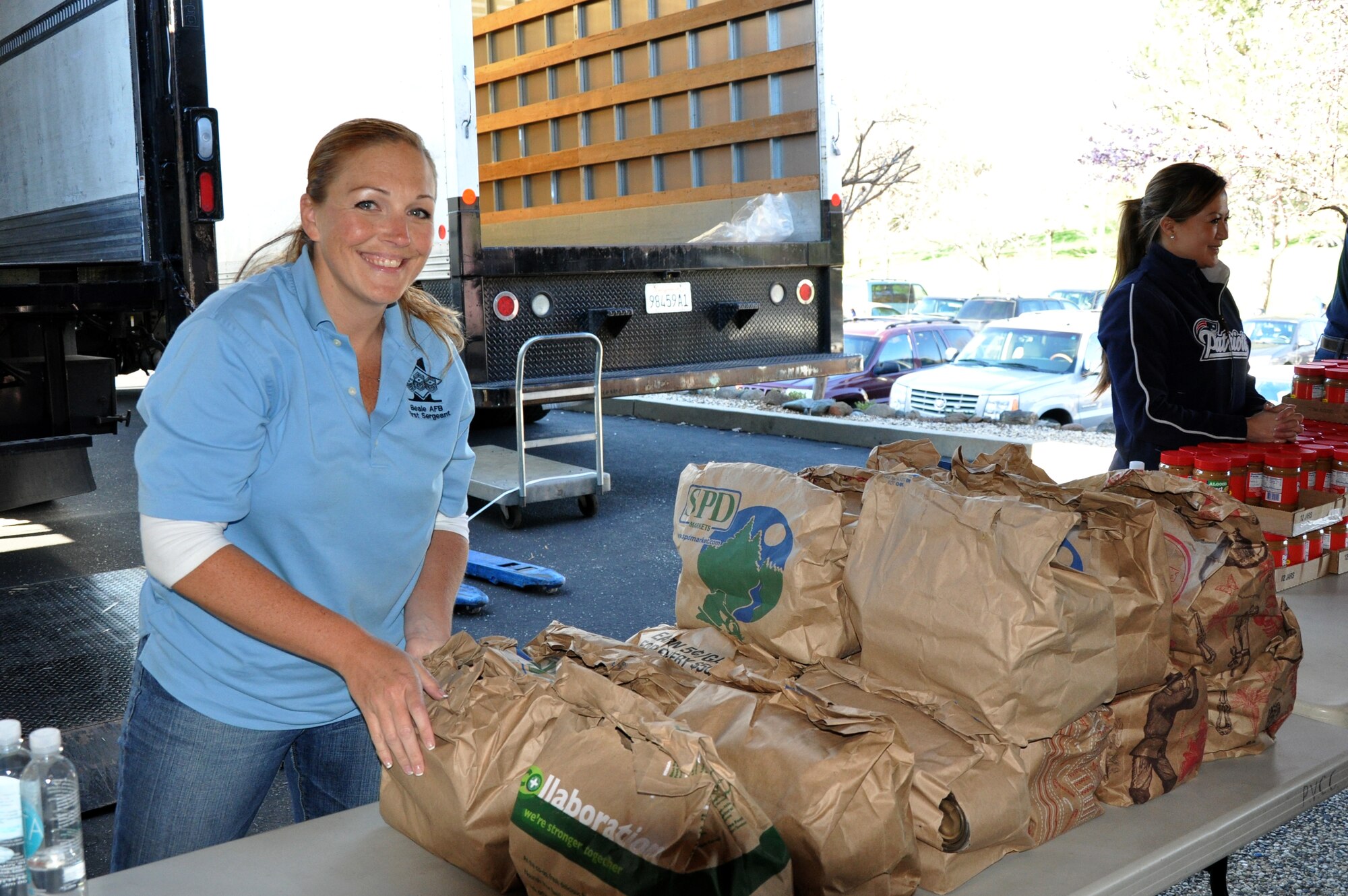 Master Sgt. Amy Riley, 9th Maintenance Squadron first sergeant, distributes bags of canned goods during a food drive in Penn Valley, Calif., March 11, 2014. Riley and other Beale first sergeants assembled more than 400 bags of canned goods. (U.S. Air Force photo by Staff Sgt. Robert M. Trujillo/Released)