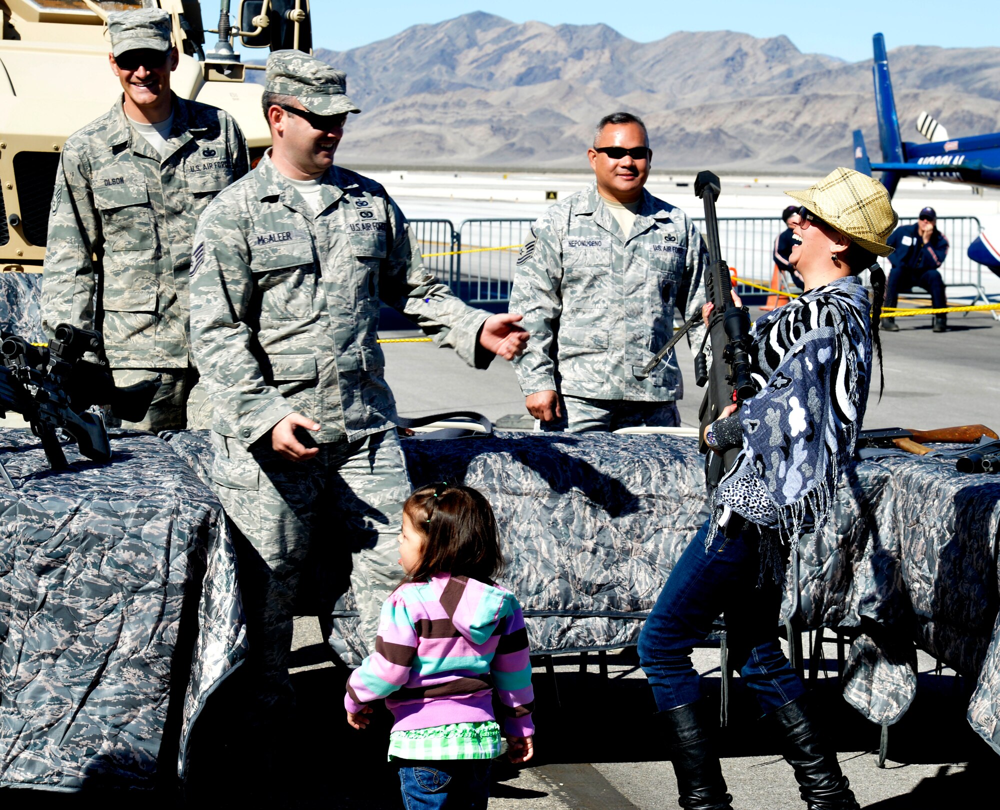 Members from the 99th Ground Combat Training Course help Yaneth Martinez hold a M-107 .50 caliber long range rifle during Indian Springs Appreciation Day March 11, 2014, at Creech Air Force Base, Nev.  Students and members of the local community attended the annual event to learn about the base’s various Air Force missions. (U.S. Air Force photo by Staff Sgt. A.K./Released)