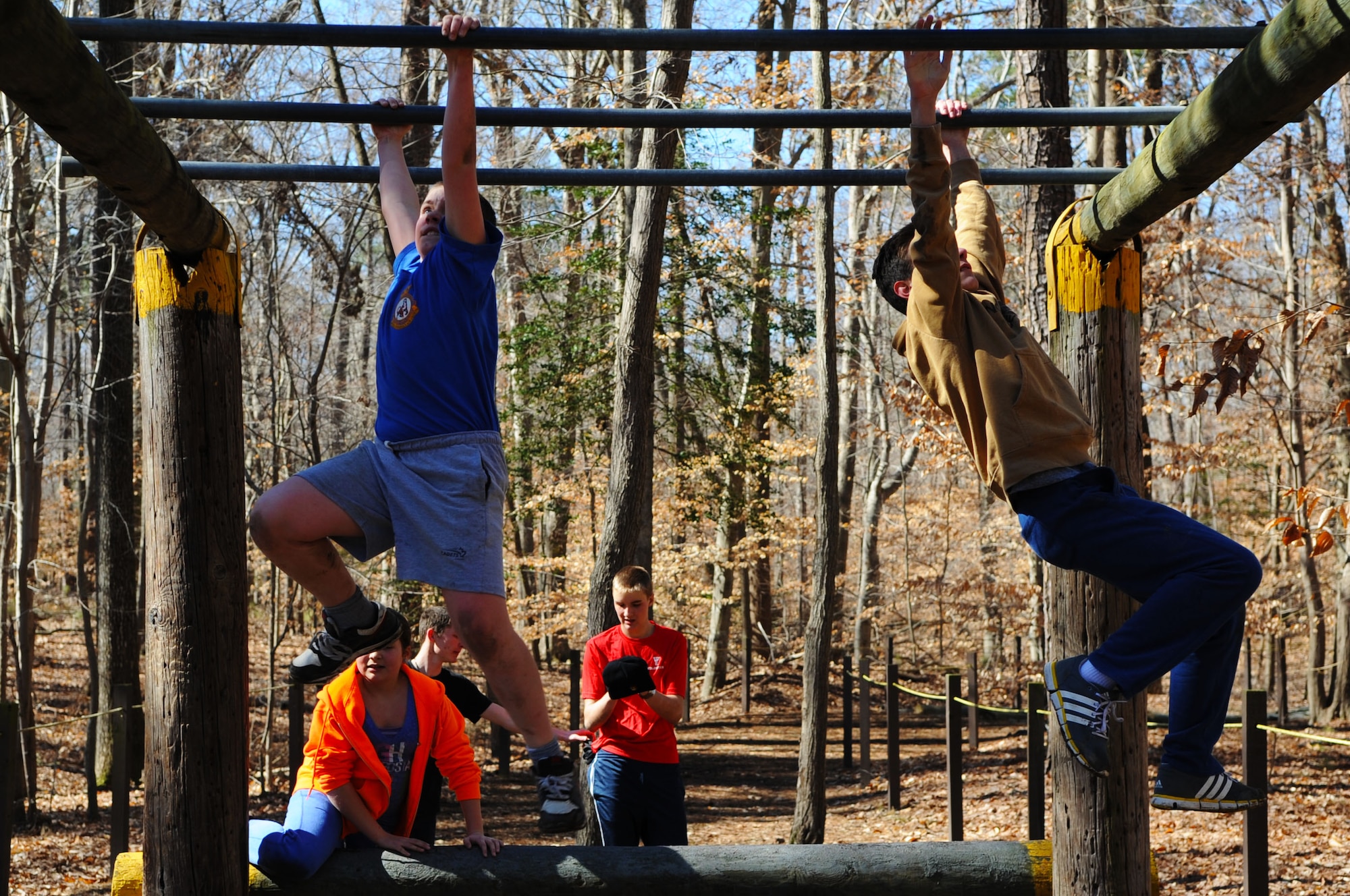 Royal Canadian Air Cadets from the 173rd Tigers Squadron and 342nd Bedford Lions Squadron navigate monkey bars during an obstacle course run-through at Fort Eustis, Va., March 13, 2014. The cadets came to Fort Eustis to foster better international relations and learn about the U.S. Army and Air Force. (U.S. Air Force photo by Senior Airman Austin Harvill/Released) (photo contrasted and color balanced to enhance image)