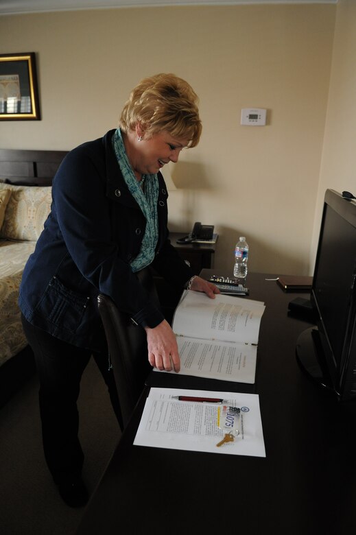 Janet Grampp, Andrews Fisher House manager, does a quality check on the “house rules” binder in a guest room March 5, 2014, at Joint Base Andrews, Md. With the help of staff and volunteers, the entire house is properly maintained, contributing to the welfare of the community living environment. (U.S. Air Force photo by Aimee Fujikawa)