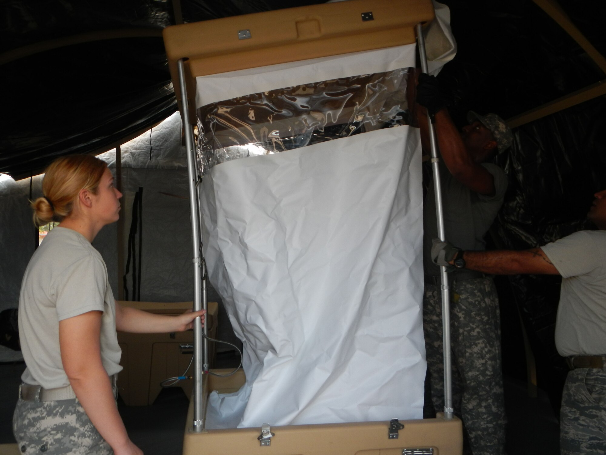 Members of Joint Task Force-Bravo’s Army Forces Battalion participate in a field sanitation training exercise assembling the E-lite Camp System, March 5, 2014.  The E-Lite Camp System provides military members the ability to take showers and perform personal hygiene while living in field conditions.  (Photo by U.S. Army Spc. Cory Cantlay)
