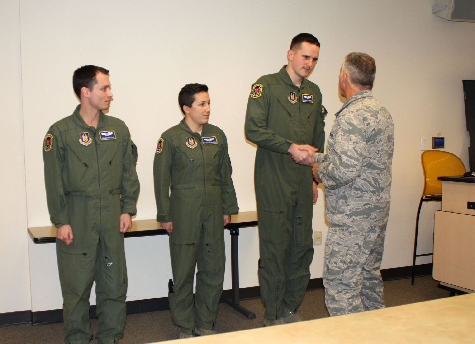 TRAVIS AIR FORCE BASE, Calif. --1st Lt. Frank Castillo, and Senior Airman Bethany Marrero, stand next to Senior Airman Nicholas Andermahr as he shakes the hand of Brig. Gen. John Flournoy, 4th Air Force commander, on March 8. All three members, who are part of the 349th Aeromedical Evacuation Squadron, were congratulated and coined by Flournoy for their dedicated patient care and overall work ethic. (U.S. Air Force photo/Senior Airman Cindy G. Alejandrez)