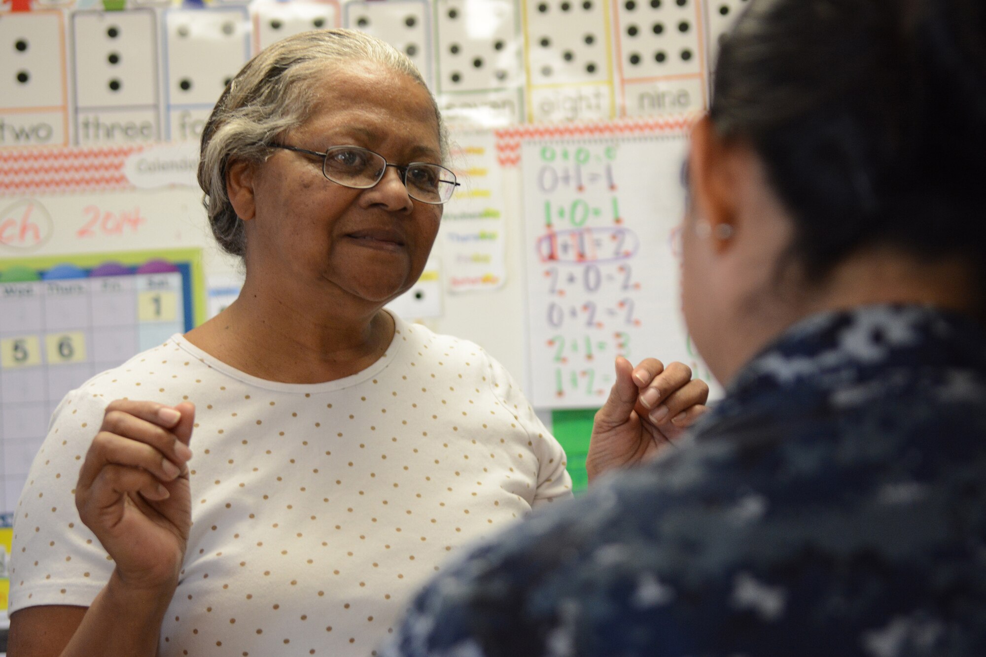 Lula Latigue, Lighthouse Christian Academy office manager, tries on her new glasses during Cajun Care 2014 in Abbeville, La., March 6, 2014. Air National Guard and Navy personnel visited the school to examine the students' and teachers' eyes, and later returned with glasses for all who needed them. (Air National Guard photo by Senior Airman Andrea F. Liechti)
