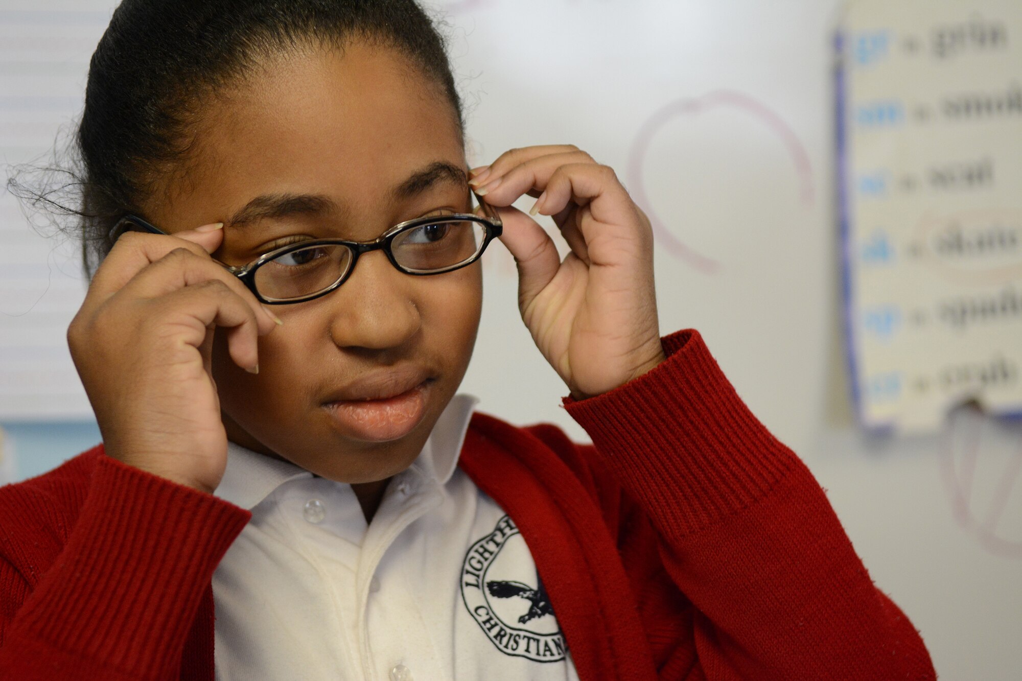 A Lighthouse Christian Academy student tries on her new glasses during Cajun Care 2014 in Abbeville, La., March 6, 2014. Air National Guard and Navy personnel visited the school to examine the students' and teachers' eyes, and later returned with glasses for all who needed them. (Air National Guard photo by Senior Airman Andrea F. Liechti)