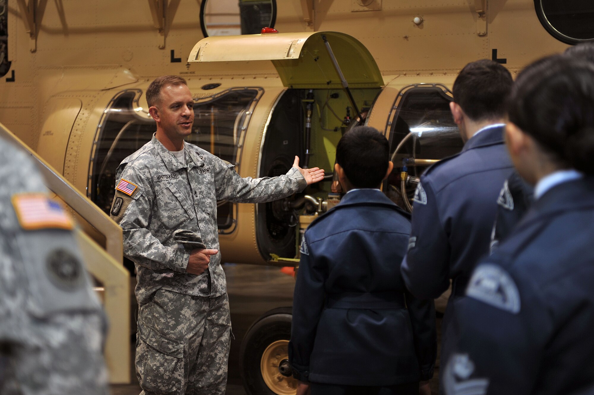U.S. Army Sgt. 1st Class Jeremy Whitaker,  A Company, 2nd Battalion, 210th Aviation Regiment, 128th Aviation Brigade senior instructor/writer, discusses a CH-47 Chinook cockpit trainer during a tour for Canadian Air Cadets from the 180th Mosquito Squadron at Fort Eustis, Va., March 12, 2014. Cadets also toured the U.S. Army Transportation Museum, received a military working dog demonstration and visited 7th Transportation Brigade (Expeditionary) vessels at 3rd Port. (U.S. Air Force photo by Staff Sgt. Katie Gar Ward/Released)