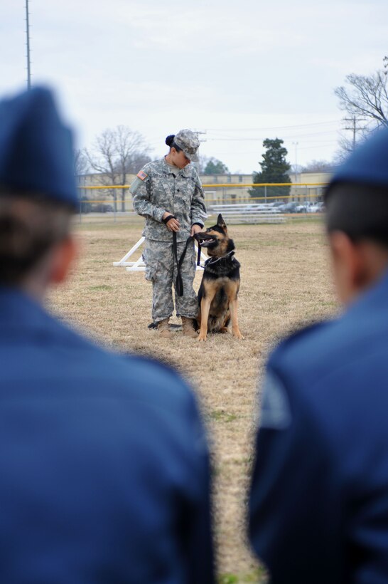U.S. Army Spc. Roxanne Cavezuela, 3rd Military Police Detachment military working dog handler, prepares to conduct obedience training with her dog, MWD Chek,  a patrol explosives detector dog, during a demonstration for Canadian Air Cadets from the 180th Mosquito Squadron at Fort Eustis, Va., March 12, 2014. The obedience training allows the working dogs to execute commands in exchange for a reward or toy. (U.S. Air Force photo by Staff Sgt. Katie Gar Ward/Released)