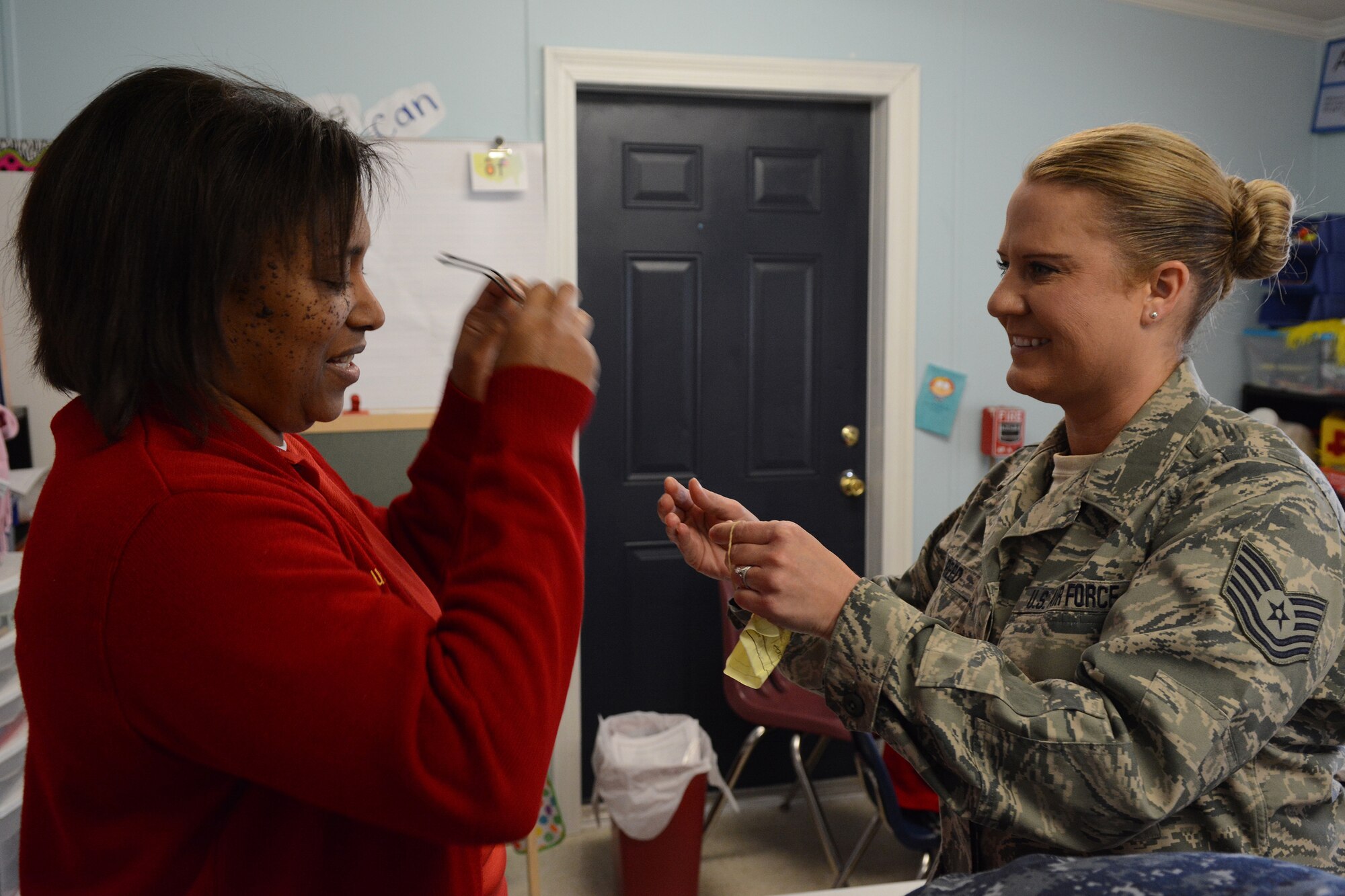 Tech. Sgt. Michelle Reed, 153rd Medical Group optometry technician, gives a pair of glasses to one of the Lighthouse Christian Academy teachers during Cajun Care 2014 in Abbeville, La., March 6, 2014. Air National Guard and Navy personnel visited the school to examine the students' and teachers' eyes, and later returned with glasses for all who needed them. (Air National Guard photo by Senior Airman Andrea F. Liechti)