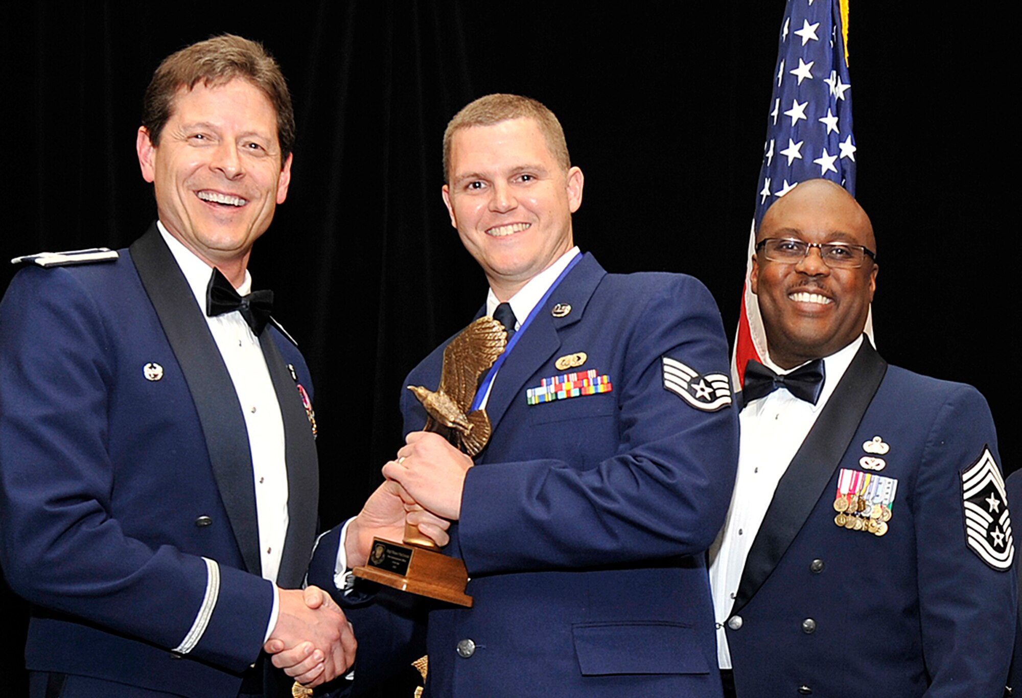 COLORADO SPRINGS, Colo. Staff Sgt. Shawn MacDonald, center, received his trophy for being recognized as the noncommissioned officer of the year from Col. Courtney Arnold, left, 302nd Airlift Wing commander, and Chief Master Sgt. Otis Jones, the wing’s command chief, during an awards banquet March 1 here. Other winners from the Air Force Reserve Command’s 302nd Airlift Wing included Senior Airman Paul Basirico, airman of the year, 302nd Aircraft Maintenance Squadron, Senior Master Sgt. Vicki Robertson, senior noncommissioned officer of the year, 302nd Force Support Squadron, first sergeant of the year was Master Sgt. Jayson Heeks, 52nd Airlift Squadron, company grade officer of the year was Capt. Craig Gulledge, 52nd AS (attached to the 302nd Aeromedical Staging Squadron and the field grade officer of the year was Lt. Col. Gregory  Berry, 302nd operations support squadron. MacDonald works for the 302nd FSS. The annual 302nd AW awards banquet is held to publicly recognize the outstanding achievements of individuals throughout the wing. (U.S. Air Force photo/Dennis Howk)
