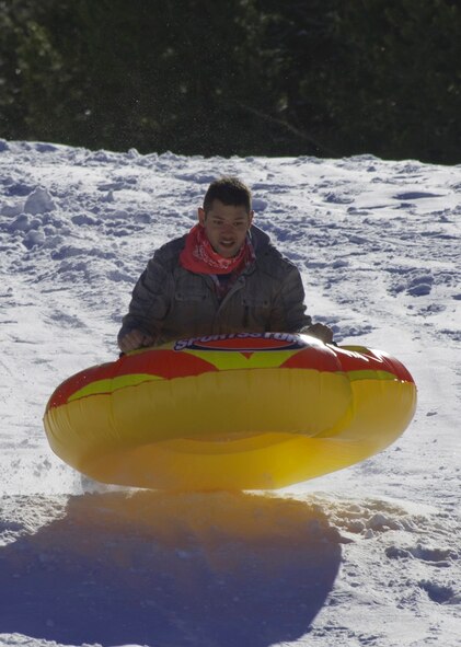 140308-F-ZZ999-001 Airman 1st Class Brandon Valle, 90th Missile Wing Public Affairs, takes air March 8 while riding an inner tube down a hill during an Outdoor Recreation trip. Outdoor Rec. took a group of 12 to the Happy Jack Recreational area, where the group broke off and went tubing, snow-shoe hiking or hung out around the bus for hot cocoa. (U.S. Air Force photo by Gary Sakura)