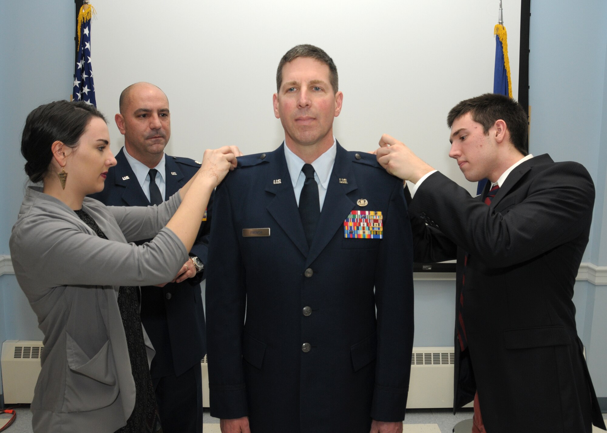 PEASE AIR NATIONAL GUARD BASE, N.H. -- Colonel Jed. J. French is pinned on the rank of colonel by his children, Amelia and Jacob French, during a promotion ceremony, Pease Air National Guard Base, N.H., March 9 2014 as Lt. Col. Anthony Picano looks on. French is the Joint Judge Advocate for the N.H. National Guard, Joint Forces Headquarters. He enlisted in the United States Army in 1983 and served  in the Calvary along the border with East and West Germany. French is a graduate of the University of Maine Law School and served in Afghanistan during 2010-2011. (U.S. Air National Guard photo by Staff Sgt. Curtis J. Lenz)
