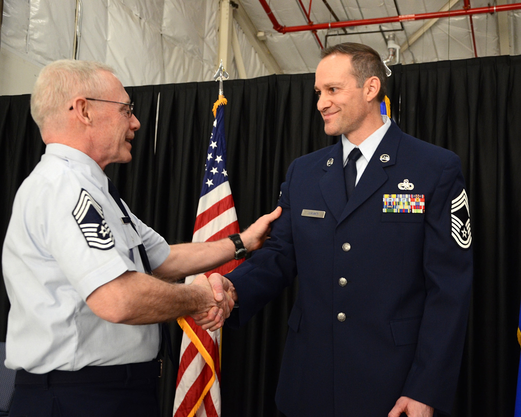 PEASE AIR NATIONAL GUARD BASE, N.H. -- Chief Master Sgt. John M. Menton, 157th Maintenance Group, congratulates newly promoted Chief Master Sgt. Michael W. Juranty, also assigned to the 157th Maintenance Group, upon his promotion to the enlisted force's most senior rank, March 9, 2014. Juranty is a traditional member of the maintenance group and the first to hold the enlisted position in more four years. (N.H. National Guard photo by Tech. Sgt. Mark Wyatt/RELEASED)
