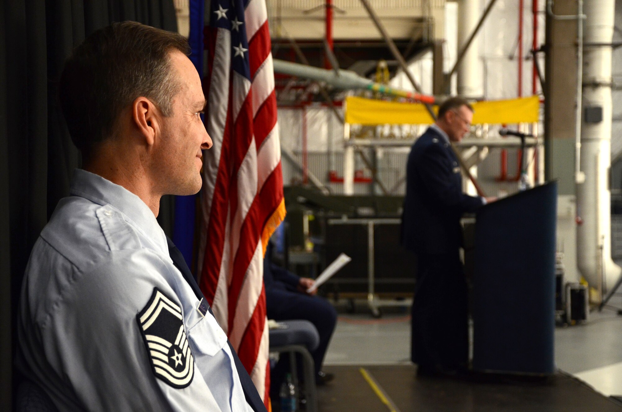 PEASE AIR NATIONAL GUARD BASE, N.H. -- Senior Master Sgt. Michael W. Juranty, 157th Maintenance Group Aircraft Maintenance superintendent, looks out over the crowd during a promotion ceremony to chief master sergeant in Hanger 254 as Lt. Col. John W. Pogorek, 157th Maintenance Group commander, speaks at the podium here March 9, 2014. Juranty is a traditional member of the maintenance group and the first to hold the enlisted position in more four years. (N.H. National Guard photo by Tech. Sgt. Mark Wyatt/RELEASED)