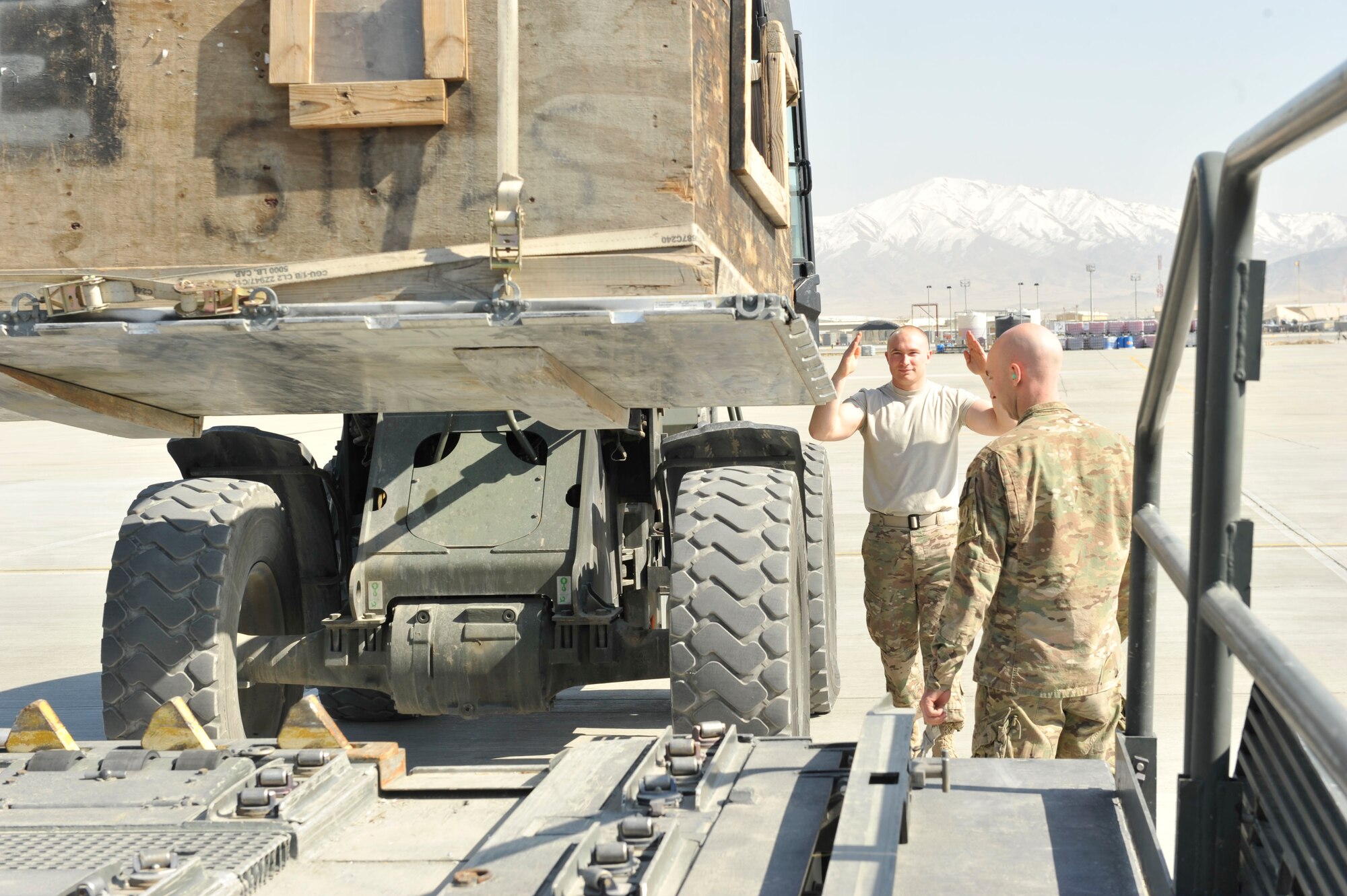 U.S. Air Force Technical Sgt. Shane Long guides a forklift delivering a pallet to a loader that will then move the cargo to an aircraft at Bagram Airfield, Afghanistan, Feb. 28, 2014. Long was deployed from the 109th Airlift Wing, New York Air National Guard.(U.S. Air Force photo by Senior Master Sgt. Gary J. Rihn/Released)