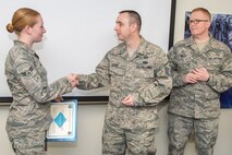 HANSCOM AIR FORCE BASE, Mass. – Hanscom first sergeants present Airman 1st Class Crystal Cardin the Diamond Sharp Award in the Brown Building March 6. From left to right, Cardin, 66th Comptroller Squadron, Master Sgt. Jason L. Oliver, 66th Air Base Group first sergeant and Master Sgt. Stephen Willis, 66th Security Forces Squadron first sergeant selected Cardin as the recipient of the Diamond Sharp Award for performance reflecting the highest standard of professionalism and pride. (U.S. Air Force photo by Rick Berry)