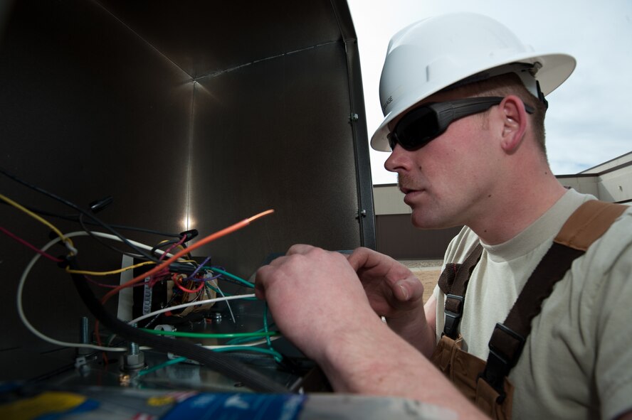 Airman 1st Class Joseph Savage, 28th Civil Engineer Squadron electrical systems technician, connects wires to a street light prior to installing it at Ellsworth Air Force Base, S.D., March 10, 2014. The street lamp was damaged by cold weather and high winds. (U.S. Air Force photo by Senior Airman Alystria Maurer/Released)