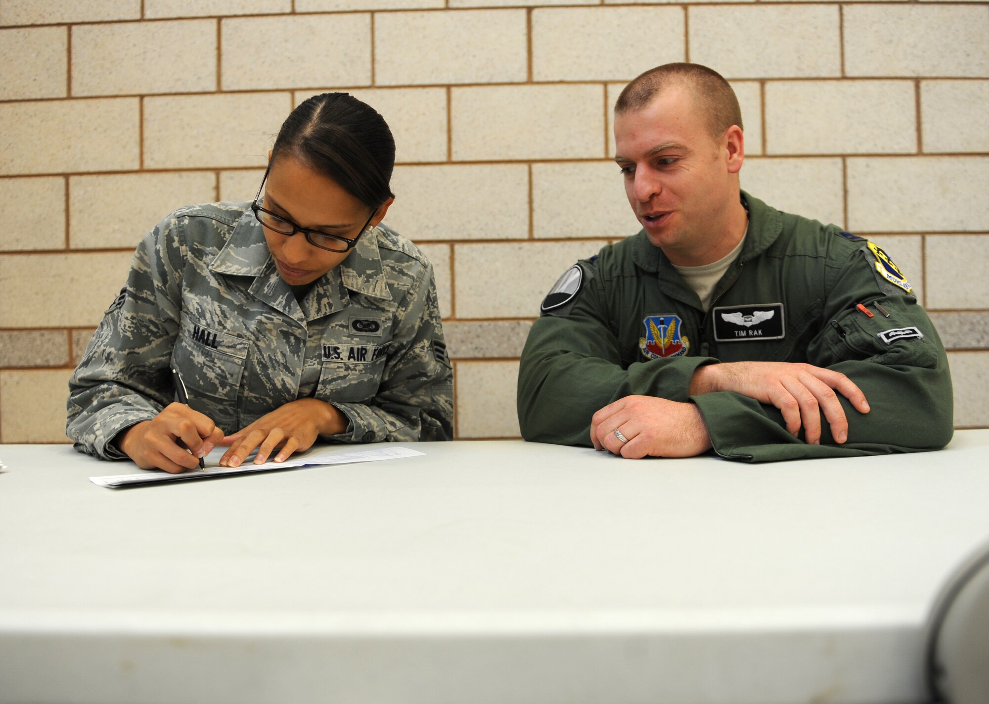 U.S. Air Force Senior Airman Shannon Hall, left, 7th Bomb Wing, signs her Air Force Assistance Fund donation slip with the help of Capt. Timothy Rak, 9th Bomb Squadron, March 3, 2014, at Dyess Air Force Base, Texas. This year’s base goal is to reach $115,000 in donations. To access donation forms and more general information about AFAF, visit http://www.afassistancefund.org/. (U.S. Air Force photo by Airman 1st Class Kedesha Pennant/Released)