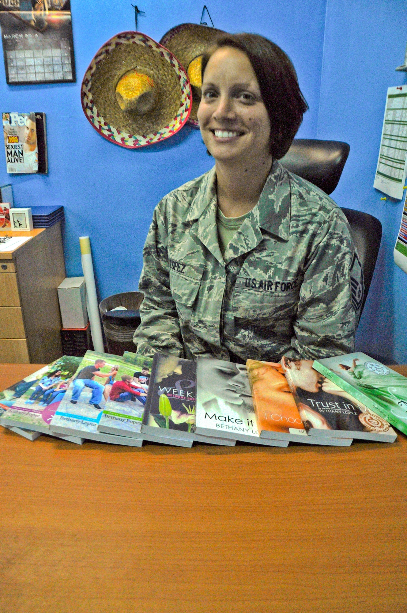 Master Sgt. Bethany Lopez, 380th Expeditionary Force Support Squadron Lodging section chief, poses for a photo with the books she has written at an undisclosed location in Southwest Asia, March 11, 2014.