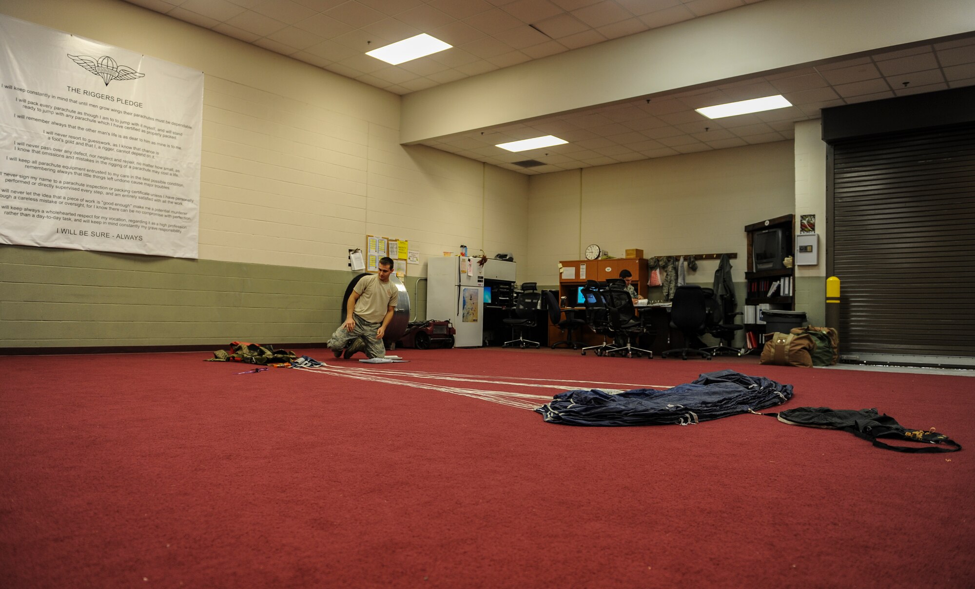 U.S. Air Force Airman 1st Class Elijah Chezem, 38th Rescue Squadron aircrew flight equipment apprentice, prepares to pack a vector parachute at Moody Air Force Base, Ga., March 11, 2014. Chezem also checked the suspension lines, the backpack and parachute to ensure everything was in order before packing. (U.S. Air Force photo by Airman 1st Class Alexis Millican/Released)