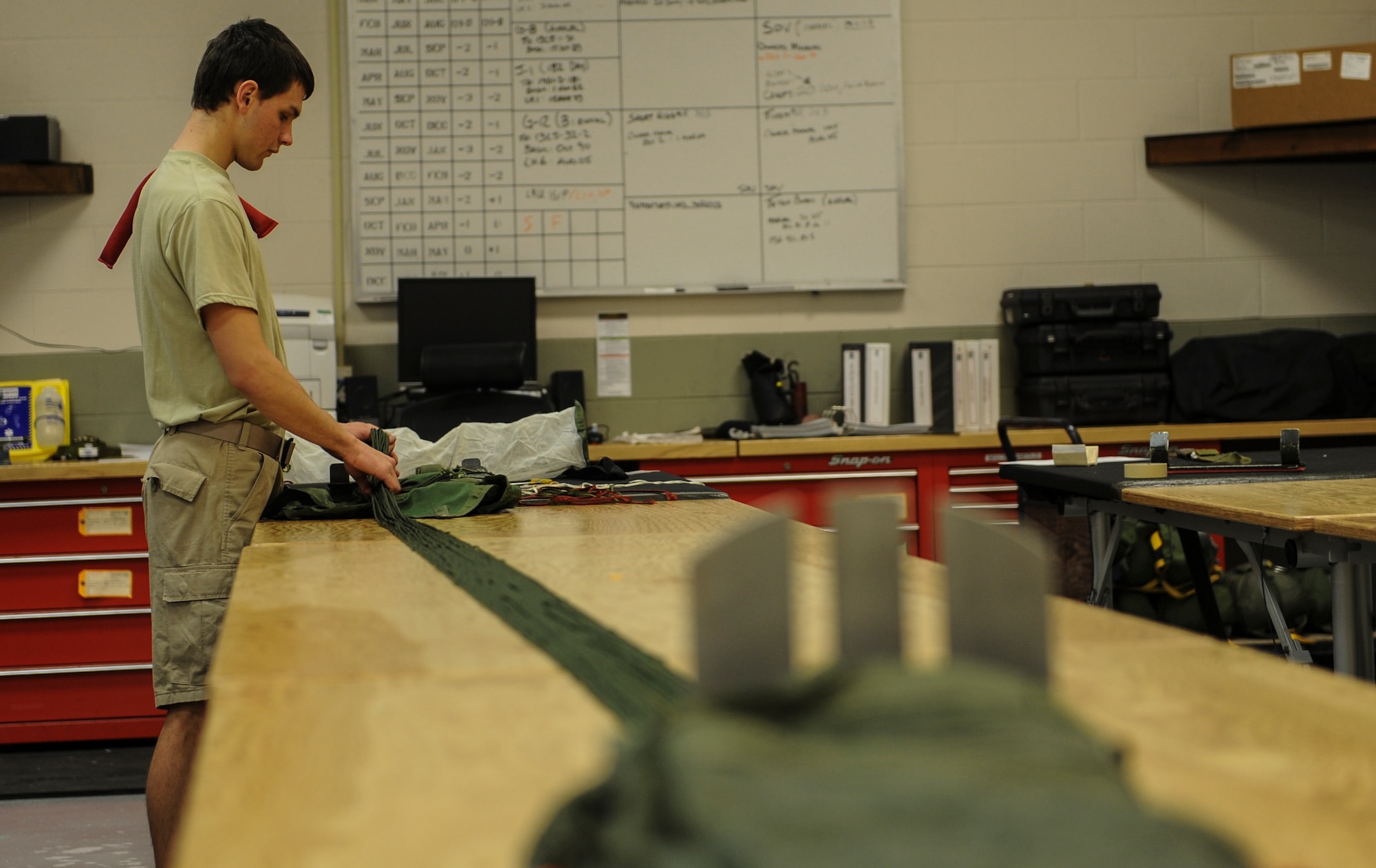 U.S. Air Force Airman 1st Class Dallas Remonda, 38th Rescue Squadron aircrew flight equipment apprentice, stows suspension lines on a parachute at Moody Air Force Base, Ga., March 11, 2014. On an average, AFE packs about 50 parachutes a week. (U.S. Air Force photo by Airman 1st Class Alexis Millican/Released)
