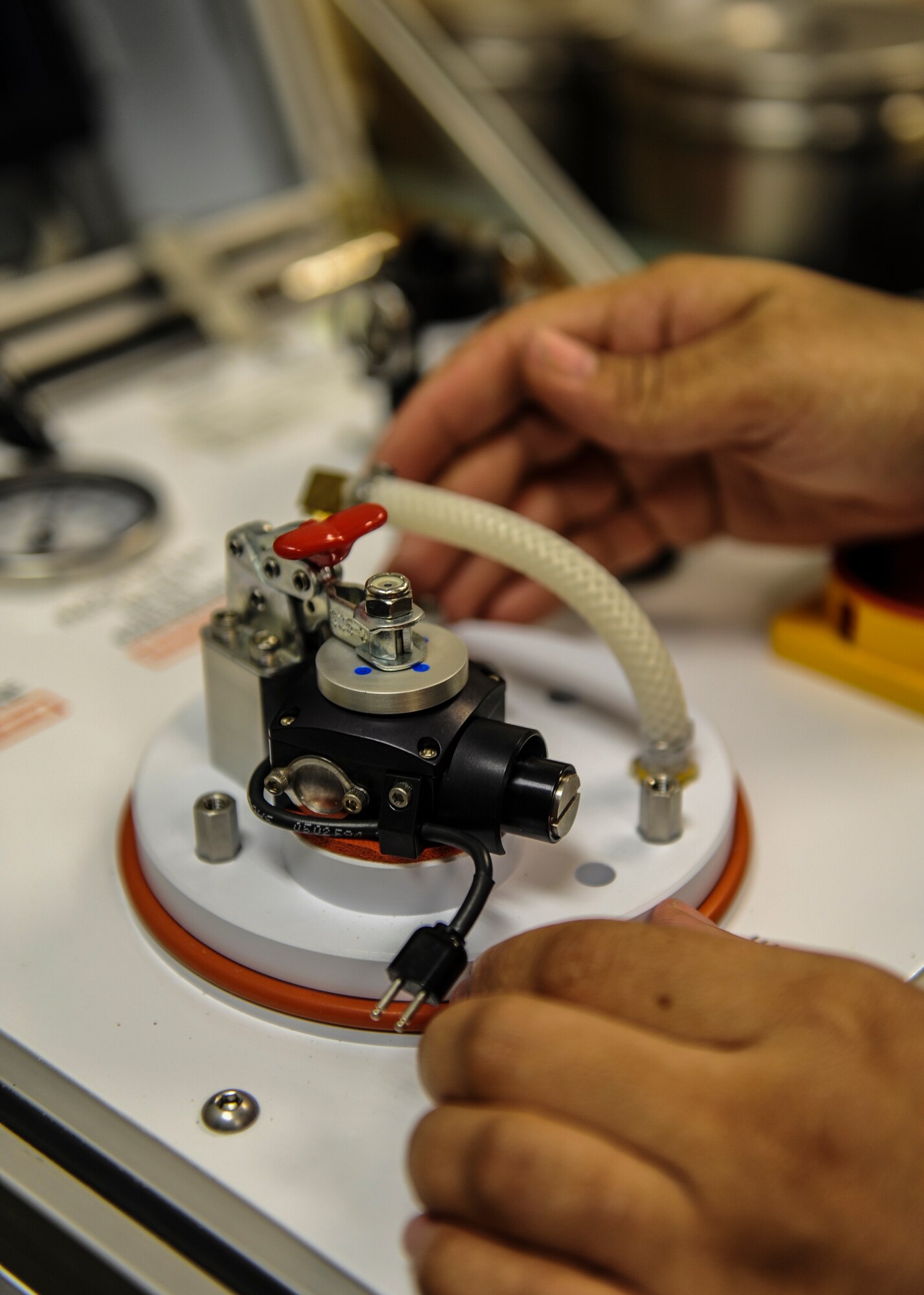 U.S. Air Force Senior Airman Sparkle Burney, 38th Rescue Squadron aircrew flight equipment journeyman, tests a regulator from a phantom mask at Moody Air Force Base, Ga., March 10, 2014. Burney performed the tests using a stand which checks to make sure the regulator is still in working condition. (U.S. Air Force photo by Airman 1st Class Alexis Millican/Released)