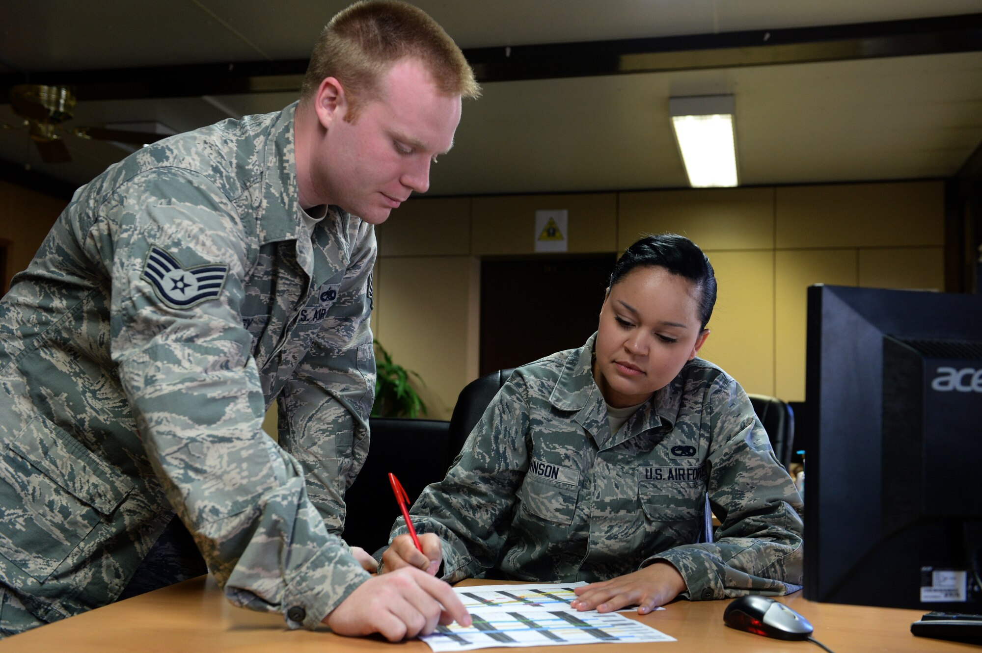 U.S. Air Force Staff Sgt. David Hartley and Airman 1st Class Chalayna Johnson, 52nd Maintenance Group maintenance operators, review the monthly flying schedule at Spangdahlem Air Base, Germany, March 10, 2014. Maintenance operations accomplishes their mission with a team of more than 100 people, from 16 different jobs, in eight sections. (U.S. Air Force photo by Senior Airman Alexis Siekert/Released)