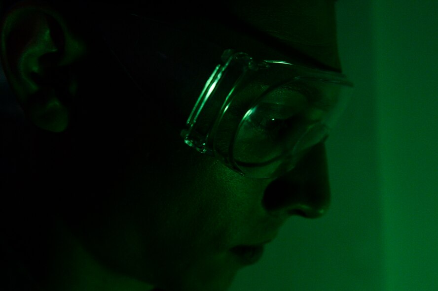 U.S. Air Force Airman 1st Class Christopher Garcia, a  52nd Equipment Maintenance Squadron non-destructive inspection apprentice from Tucson, Ariz., dips a training part in fluorescent penetrate March 7, 2014, at Spangdahlem Air Base, Germany. The chemical glows to reveal cracks after the NDI Airmen submerge the parts. (U.S. Air Force photo by Senior Airman Rusty Frank/Released)