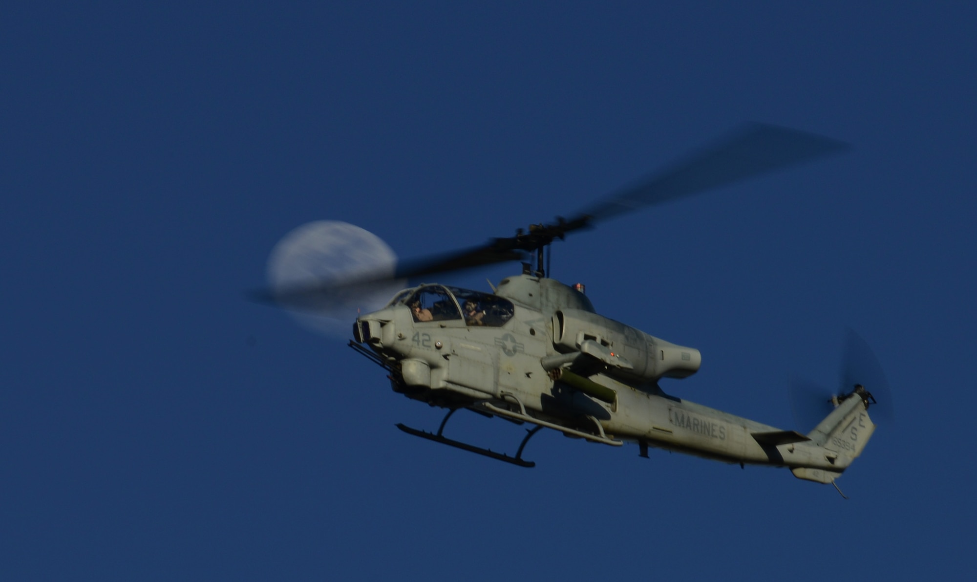 A U.S. Marine Corps AH-1 SuperCobra flies around performing a show of force at the Juniper Butte Bombing Range March 12, 2014, near Mountain Home Air Force Base, Idaho. The SuperCobras are participating in the combat exercise Gunfighter Flag. The exercise is an excellent opportunity to prepare multiple joint and coalition terminal attack controller teams for upcoming deployments as well as provide proficiency training for air and ground crews. (U.S. Air Force photo by Senior Airman Benjamin Sutton/Released)