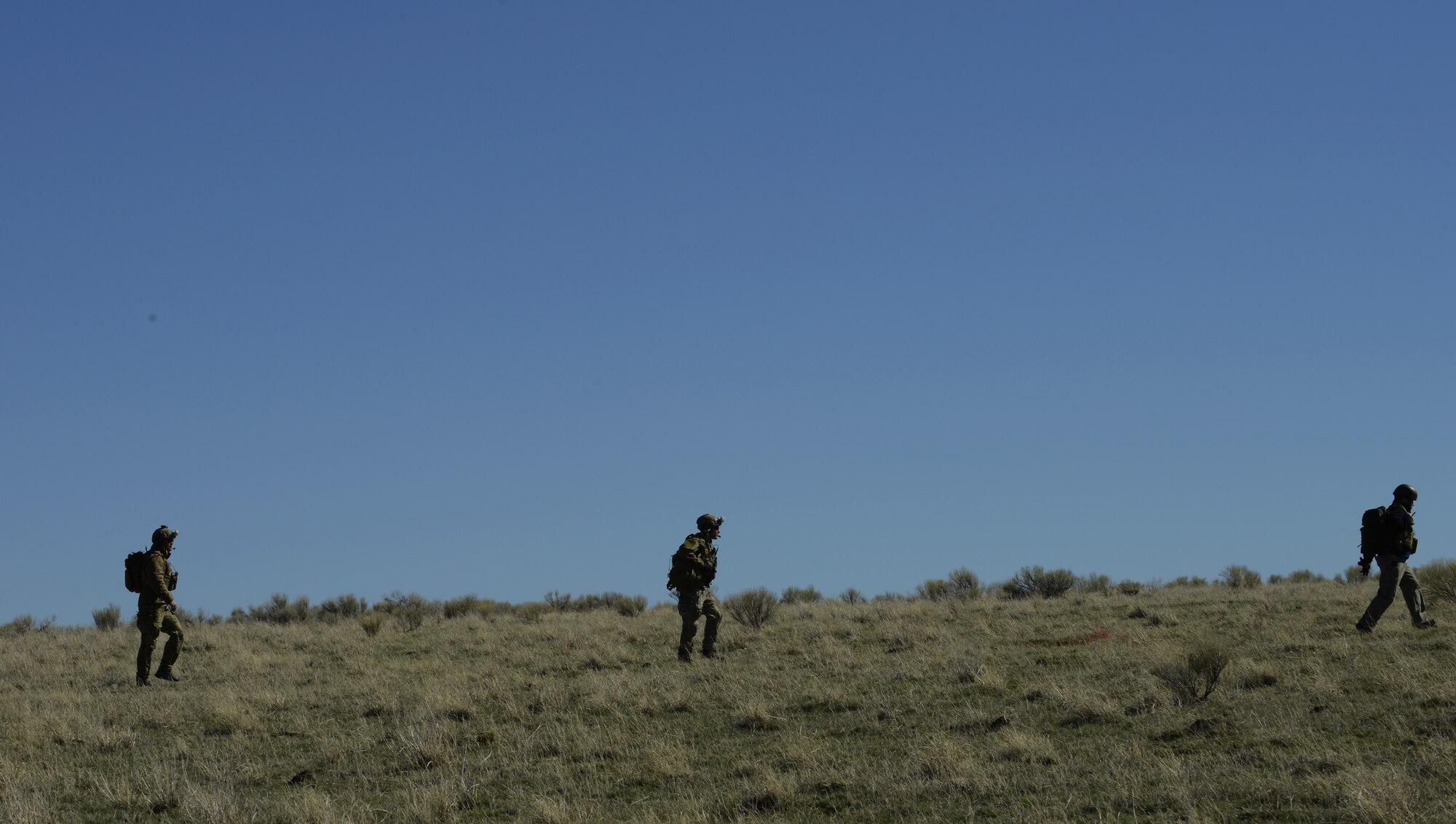 Three Combat Controllers move to helicopters March 12, 2014, at the Juniper Butte Bombing Range near Mountain Home Air Force Base, Idaho. The CCT team was one part of the exercise, which consisted of all three MHAFB fighter squadrons, more than 300 visiting Marines and British partners. (U.S. Air Force photo by Senior Airman Benjamin Sutton/Released) 
