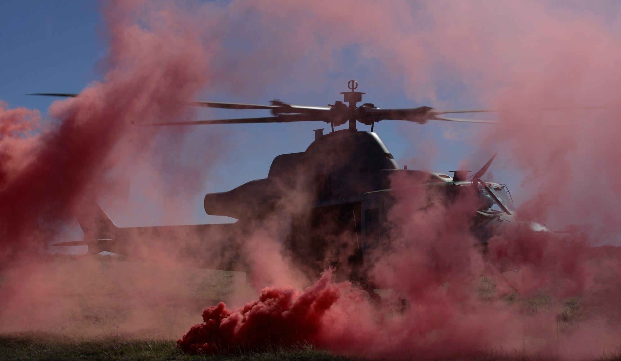 A United States Marine Corps UH-1Y Venom helicopter participating in Gunfighter Flag hovers at a landing point marked by red smoke March 12, 2014, at the Juniper Butte Bombing Range near Mountain Home Air Force Base, Idaho. Gunfighter Flag is an excellent opportunity for ground crew members to train and respond to multiple daily launches. (U.S. Air Force photo by Senior Airman Ben Sutton/Released) 
