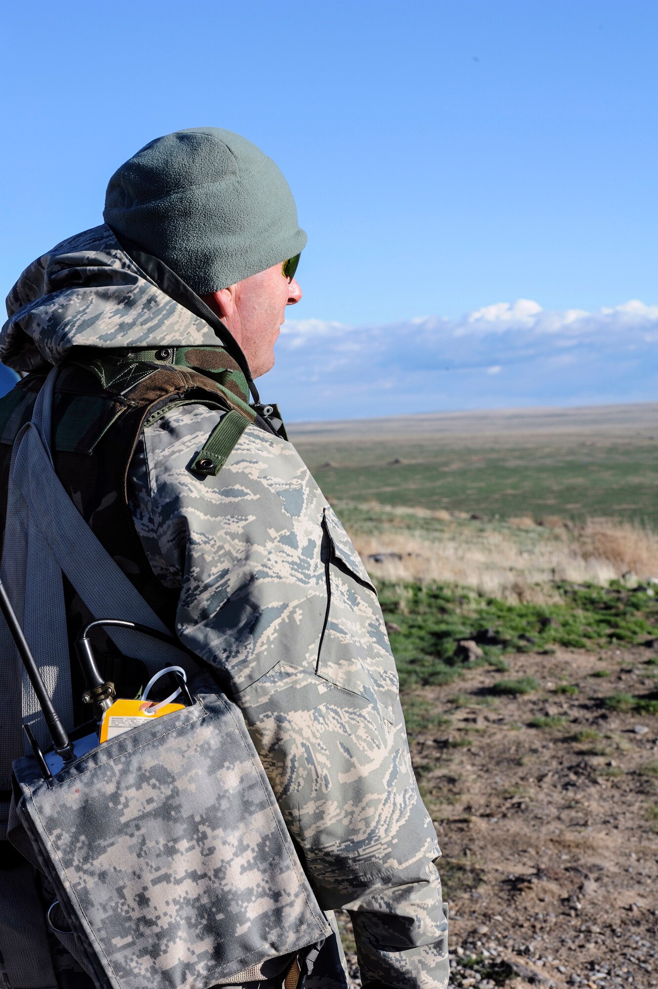 Air Force Staff Sgt. Dallas Dugan, 266th Range Squadron NCO, looks over the Saylor Creek range and awaits an incoming F-15E Strike Eagle, which will soon perform a close-air support training mission at Mountain Home Air Force Base, Idaho, March 11, 2014. The 266th RANS controls threat emitters and launches simulated ground to air rockets during the exercise. (U.S. Air Force photo by Master Sgt. Kevin Wallace/RELEASED)